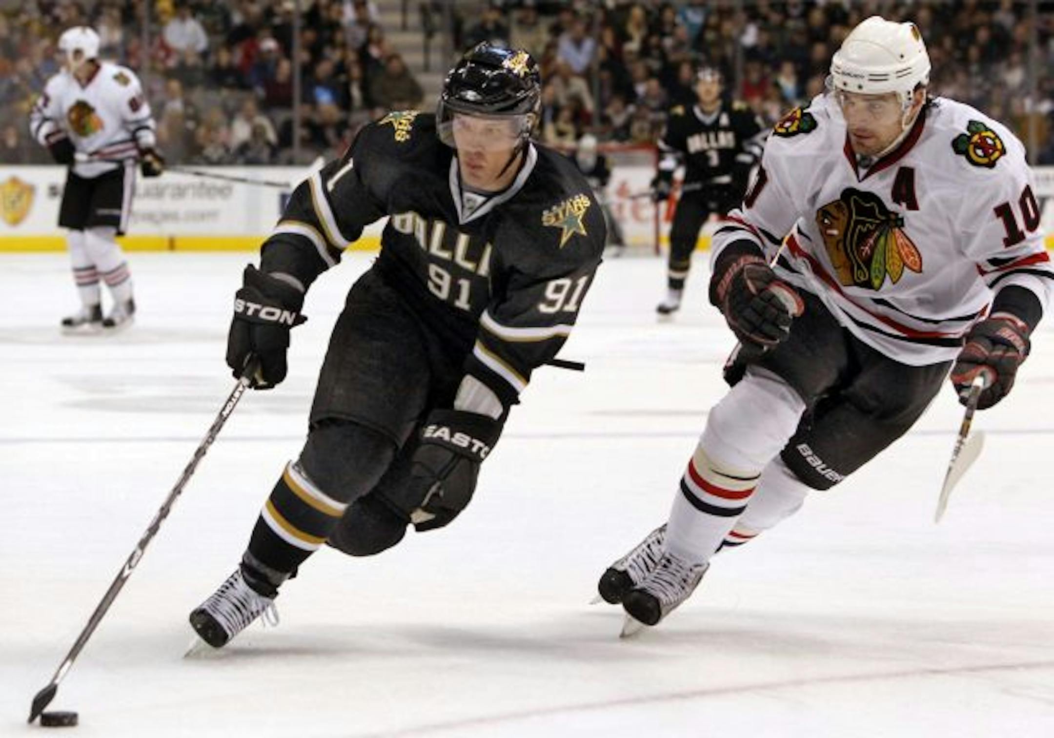 Dallas Stars' Brad Richards (91) takes the puck around Chicago Blackhawks' Patrick Sharp (10) during first-period action at American Airlines Center in Dallas, Texas, on Friday, February 11, 2011.