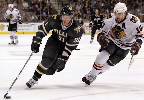 Dallas Stars' Brad Richards (91) takes the puck around Chicago Blackhawks' Patrick Sharp (10) during first-period action at American Airlines Center i