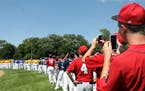 Rochester Patriots players and other teams watch and take photos on their phones of the military jet flyover for the Minnesota American Legion State B