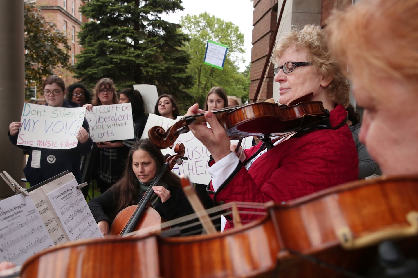 From left, cello instructor Anna Vazquez, violin instructor Ewa Bujak, and viola instructor Elizabeth Cregan played in protest in front of Derham Hall opposing cuts to the music and theater programs Thursday.