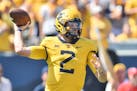 West Virginia quarterback Jarret Doege (2) makes a pass against Virginia Tech during the first half of an NCAA college football game in Morgantown, W.