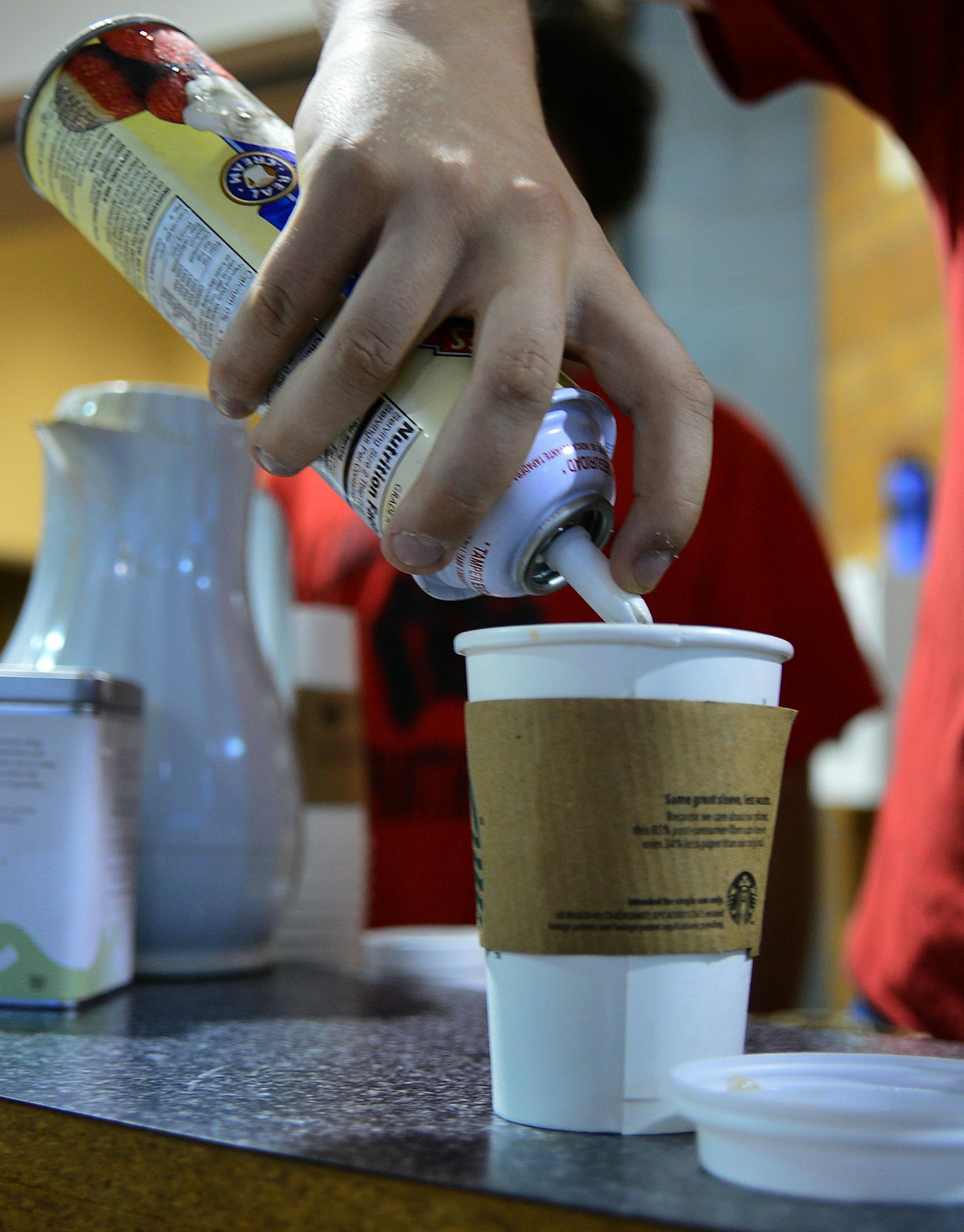 Lakeville North High School is creating a new cyber cafe, featuring Starbucks products, serving coffee, tea and other basic drinks. They're remodeling an area near the cafeteria to accommodate it and added outlets and seating. Lucas Ince worked behind the counter serving coffee to students and faculty before school. He topped off a hot chocolate with whipped cream. ] Richard.Sennott@startribune.com Richard Sennott/Star Tribune Lakeville Minnesota Wednesday 9/17/13) ** (cq)