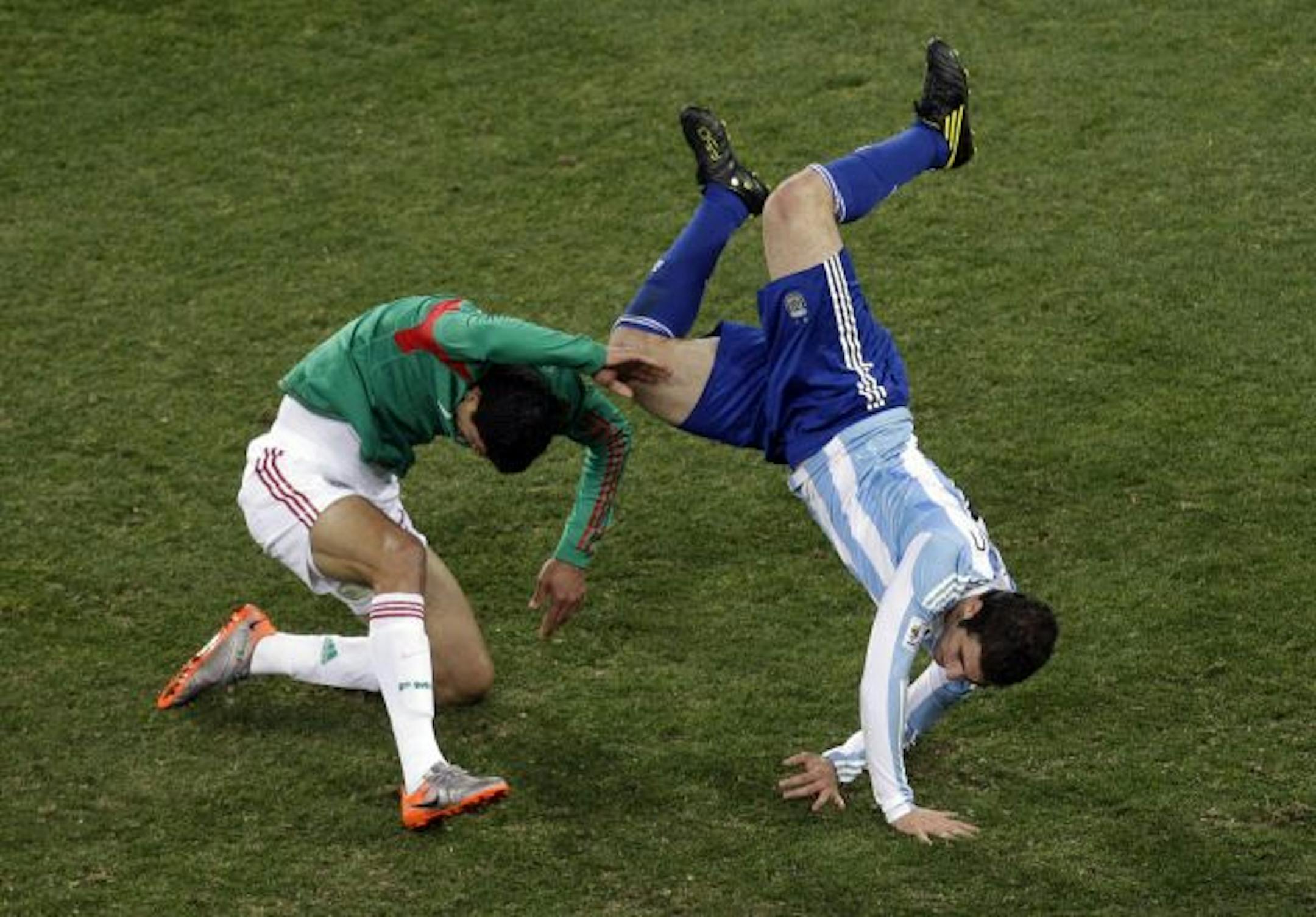 Argentina's Gonzalo Higuain, right, rolls over Mexico's Ricardo Osorio during World Cup play.