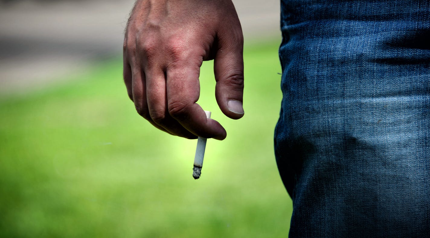 This man was smoking on the curb between Lake St next to Lake Calhoun North Beach as a courtesy to other people at the park. Smoking is already not allowed at the beaches of Lake Calhoun Park. The Minneapolis Park Board Recreation Committee is proposing to ban smoking in all city parks. Wednesday, June 4, 2014 ] GLEN STUBBE * gstubbe@startribune.com