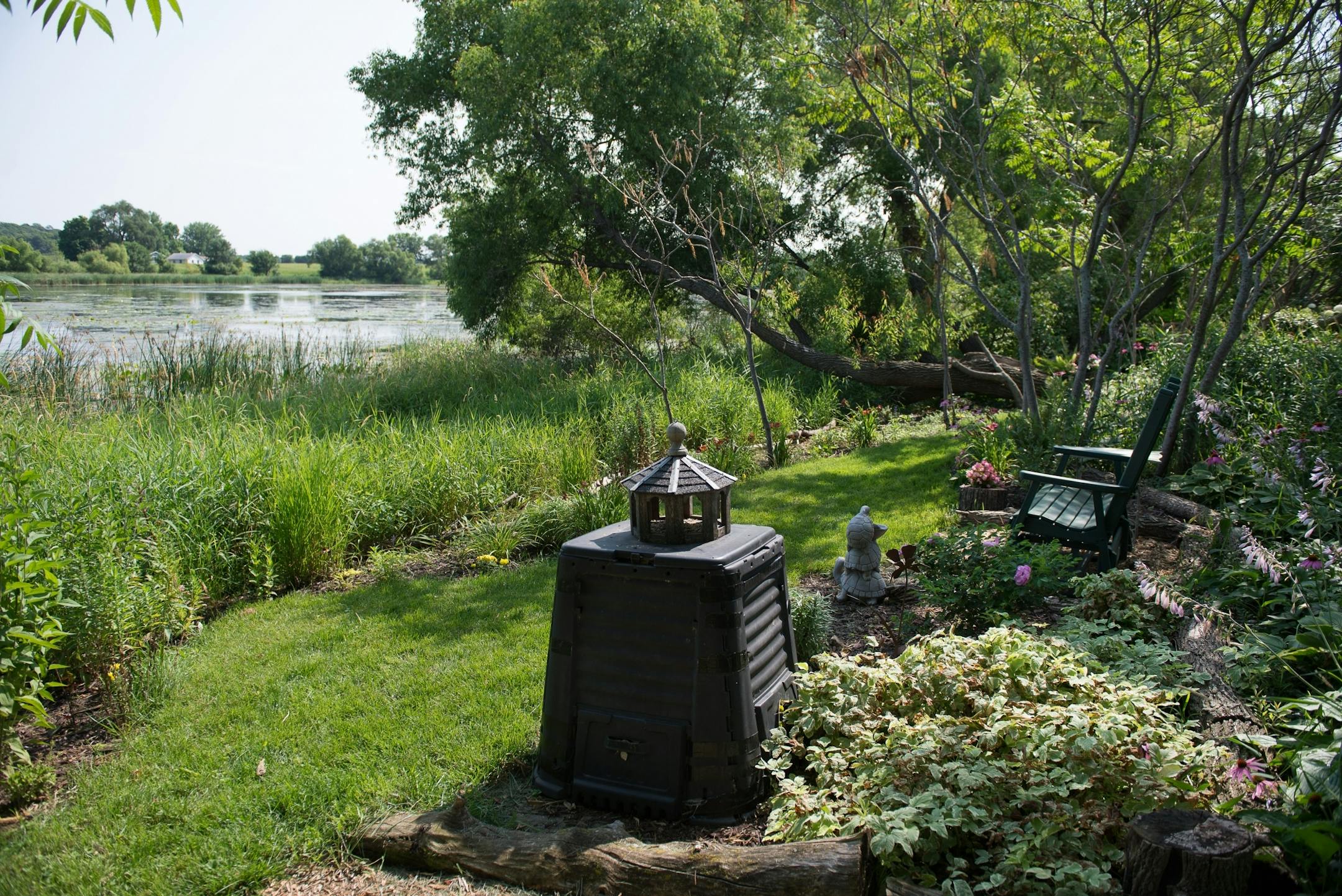 A bench with a view out over Tustin Lake sits in the common area that Dan and Nancy Engebretson garden next to their home in Elysian, Minnesota on July 31, 2014. [ Angela Jimenez/Special to the Star-Tribune angelajime@gmail.com Assignment #20035606A_ SLUG: ENGEBRETSON100114_ EXTRA INFORMATION: Since 2006, the Engebretsons have designed and tended to their own garden, and have transformed the common space near their home into a landscaped, shared garden space in the Lakeview Manor Townhome Associ