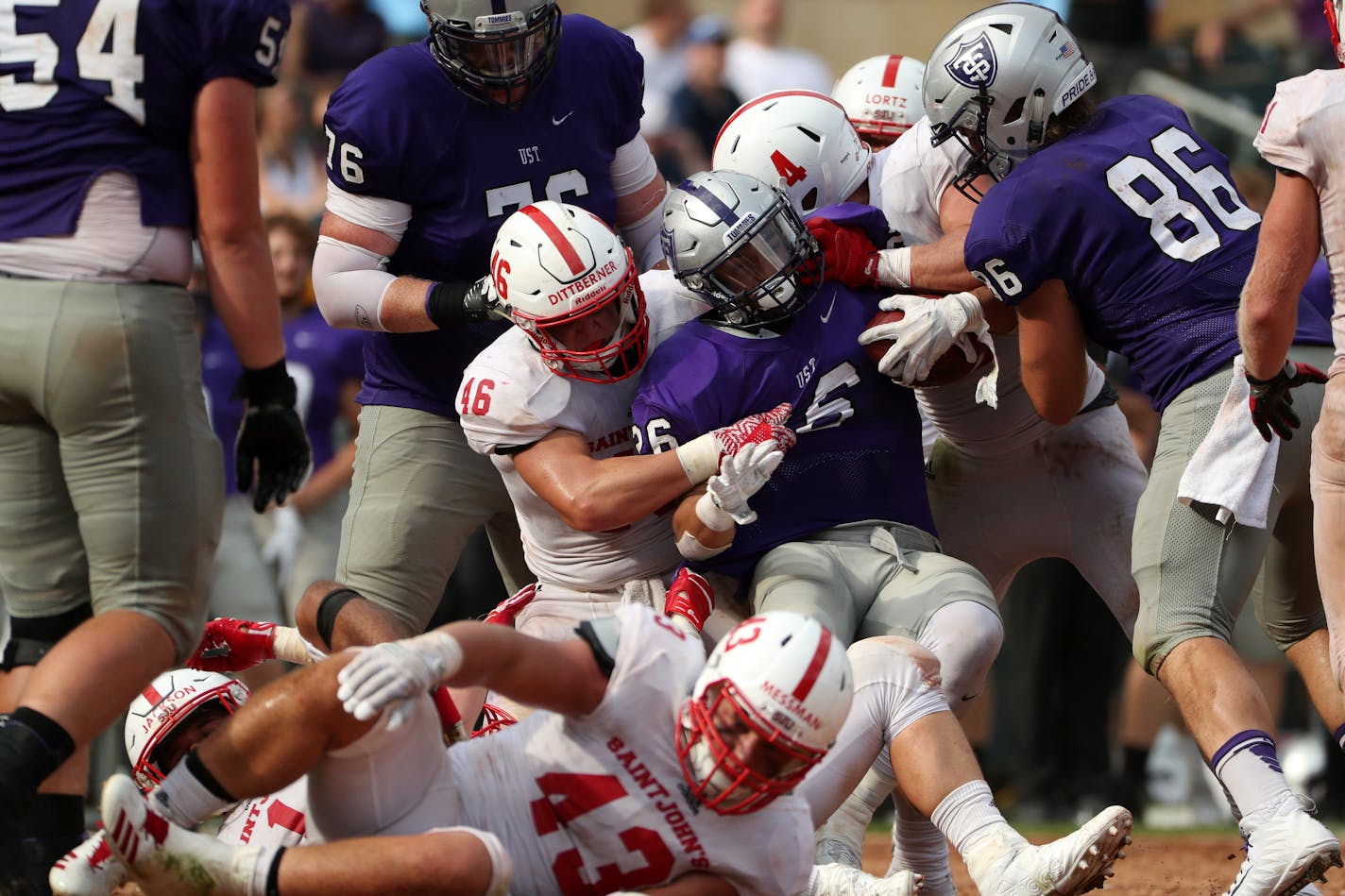 University of St. Thomas running back Josh Parks was pulled down by St. John's University defensive lineman Trevor Dittberner during a game in 2017.