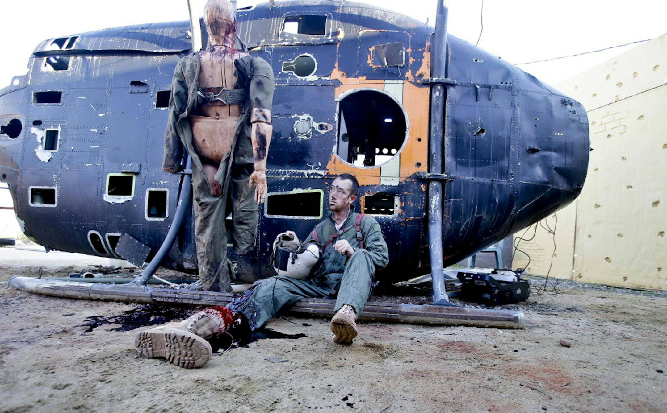 Former Navy corpsman Joel Booth, who lost a leg in Afghanistan, plays his role as a downed helicopter pilot in a military training exercise at San Diego-based Strategic Operation.