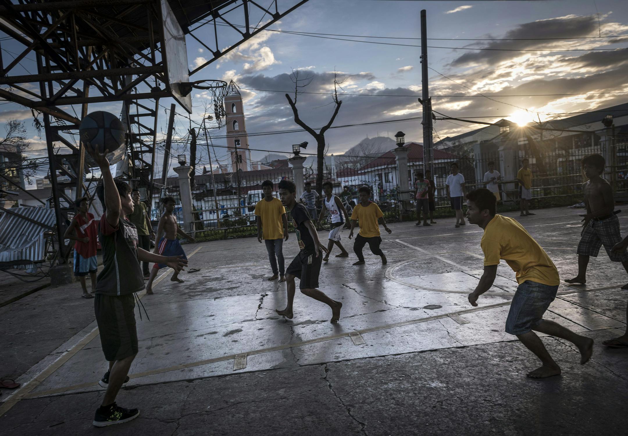 Children play basketball in Tacloban, the Philippines, Nov. 19, 2013. As the Philippines faces a multitude of questions about the needs of some 13 million people affected by the storm, it must also deal with the impact of the five million of those who are children. (Sergey Ponomarev/The New York Times)