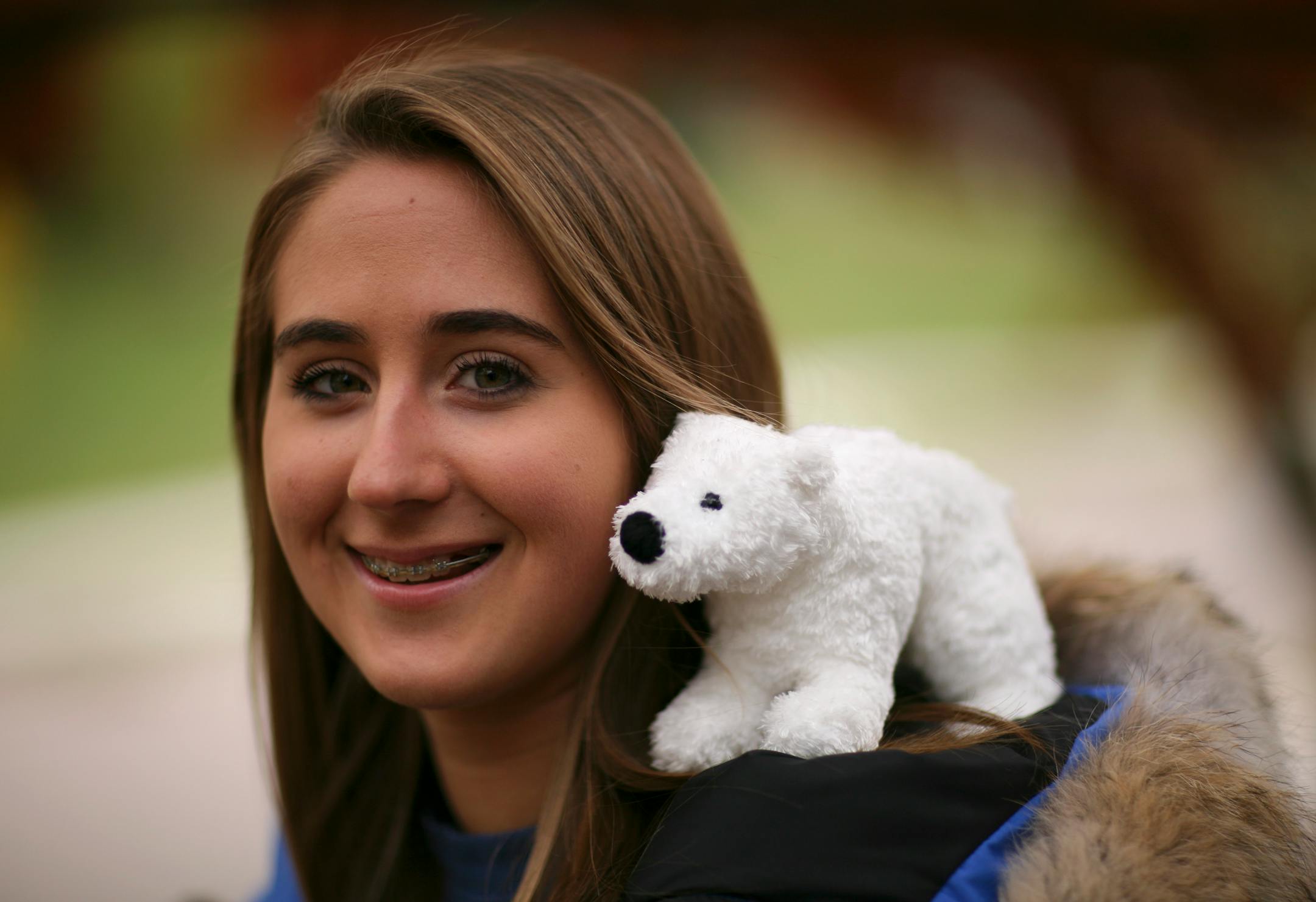 Sarah Davy on the front porch of her home in St. Paul's Como Park neighborhood. She can see the polar bear exhibit at Como Zoo from there. She's wearing a parka all participants in the Polar Bears International Arctic Ambassador program received.