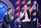 Ryan Seacrest, left, looks on as William Hung performs at the "American Idol" farewell season finale at the Dolby Theatre on Thursday, April 7, 2016, 