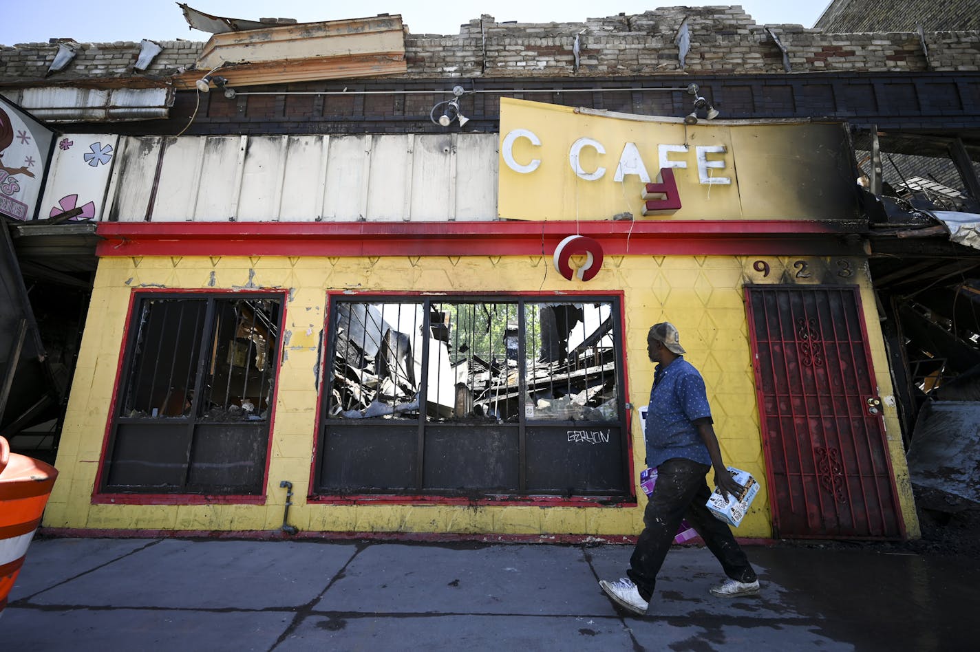 A man, who did not wish to be identified, looked over the smoldering remains of the Olympic Cafe on West Broadway as he walked past Saturday. ] aaron.lavinsky@startribune.com Protests continued in the wake of George Floyd's death in police custody on Saturday, May 30, 2020 in Minneapolis, Minn.