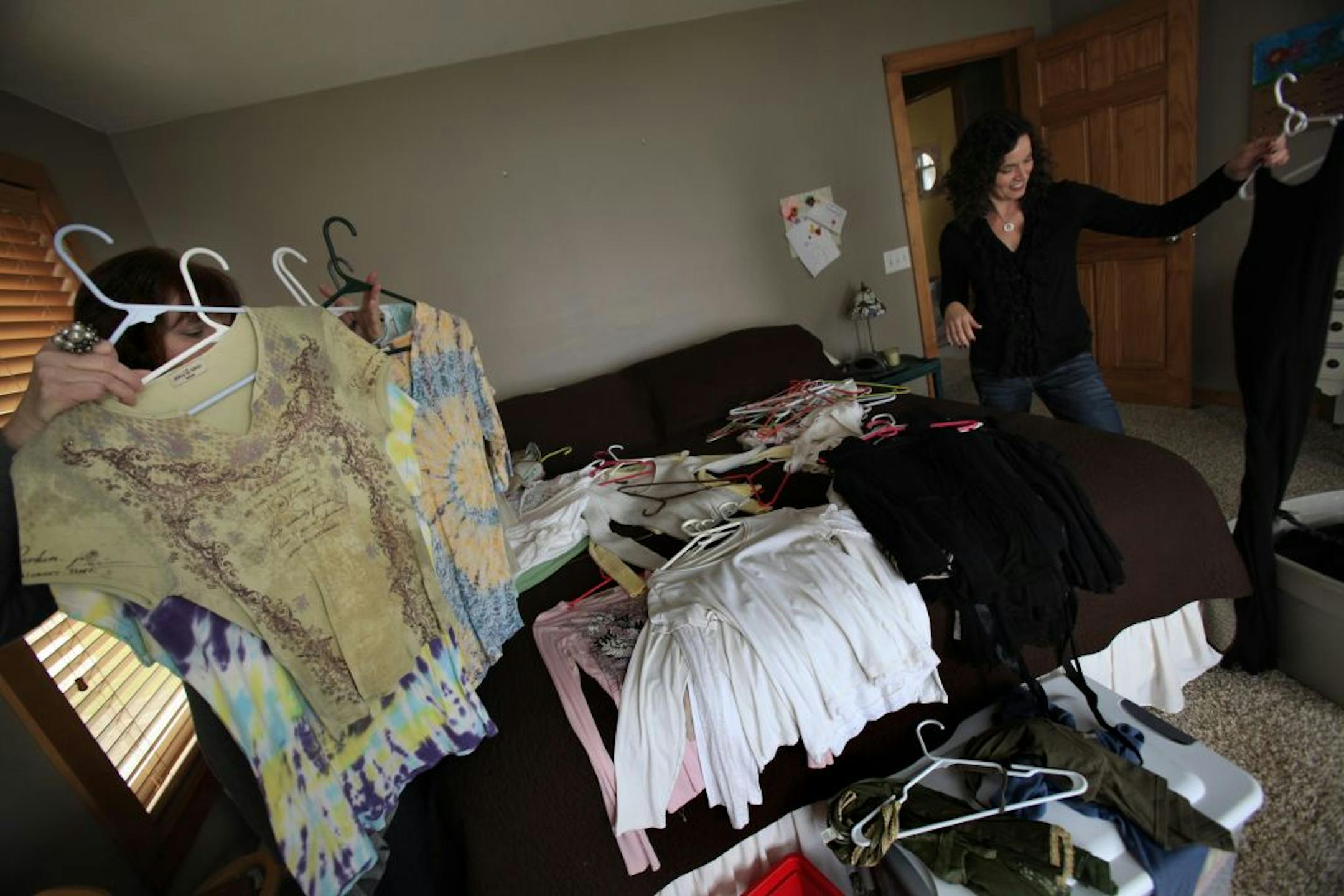 Beth Ilg, left, helped Heather Foss edit her closet by suggesting that she thin out an excess of dated tops and shorten a sleeveless black dress.