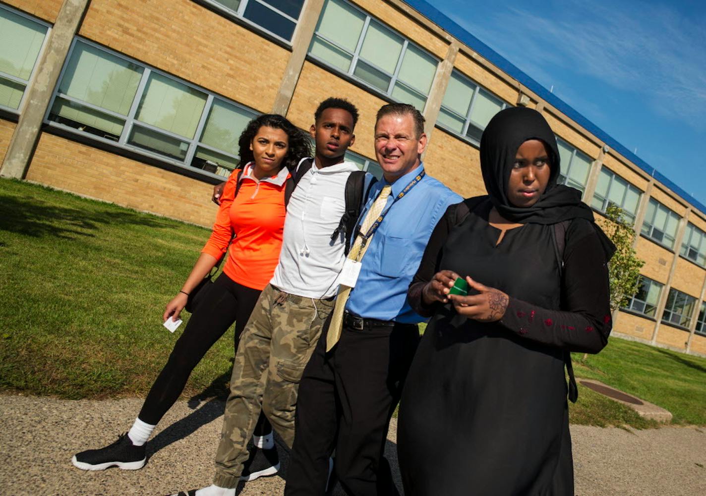 At Columbia Heights High School, students Sherouk Mohamed,17, left, Karim Muse,17, in white, and Khadra Mohamed,18, right, walked out in protest of an anti-Muslim Facebook post, allegedly by a school board member. After the protest, principal Dan Wroblewski came out to lead the students back to class.