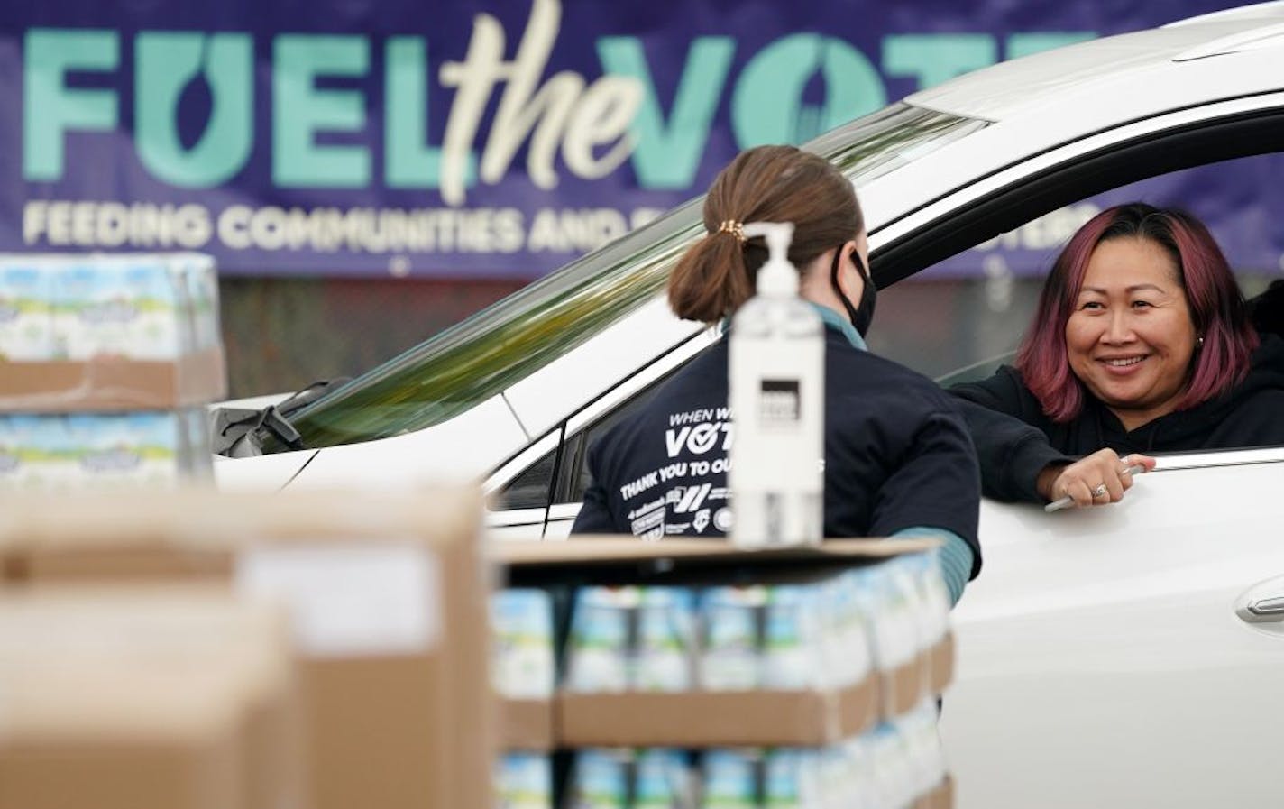 Kathy Thammavongsa talked with workers as they loaded her car with food items during a "Fuel the Vote" event Saturday.