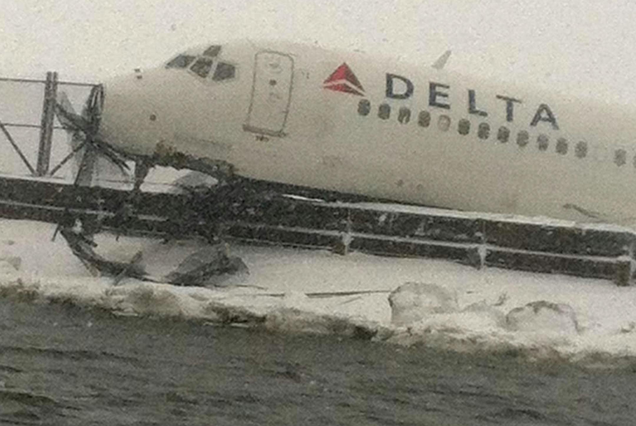 In this image released by the New York Fire Department, a Delta plane rests on a berm near the water at LaGuardia Airport in New York, Thursday, March 5, 2015. Delta Flight 1086, carrying 125 passengers and five crew members, veered off the runway at around 11:10 a.m., authorities said. Six people suffered non-life-threatening injuries, said Joe Pentangelo, a spokesman for the Port Authority of New York and New Jersey, which runs the airport. (AP Photo/New York Fire Department)
