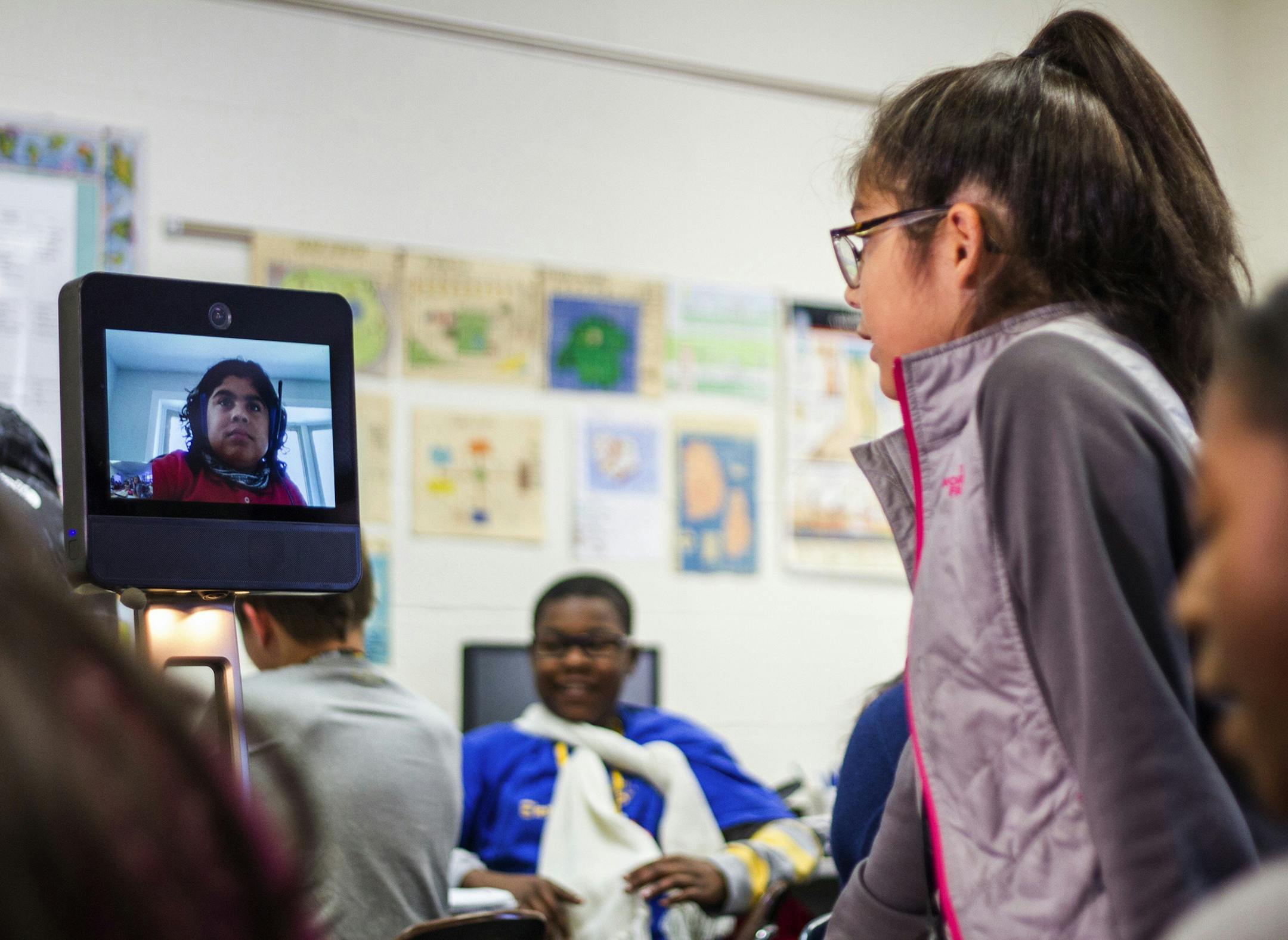 A classmate at Central Middle School in Evergreen Park, Ill. talks with Max Castillo in their sixth grade social studies class on Wednesday, Oct. 17, 2018. Max, who suffers from rare genetic disorders, uses a mobile robot to take part in class without leaving his home. (Vincent D. Johnson/Daily Southtown/TNS) ORG XMIT: 1243022