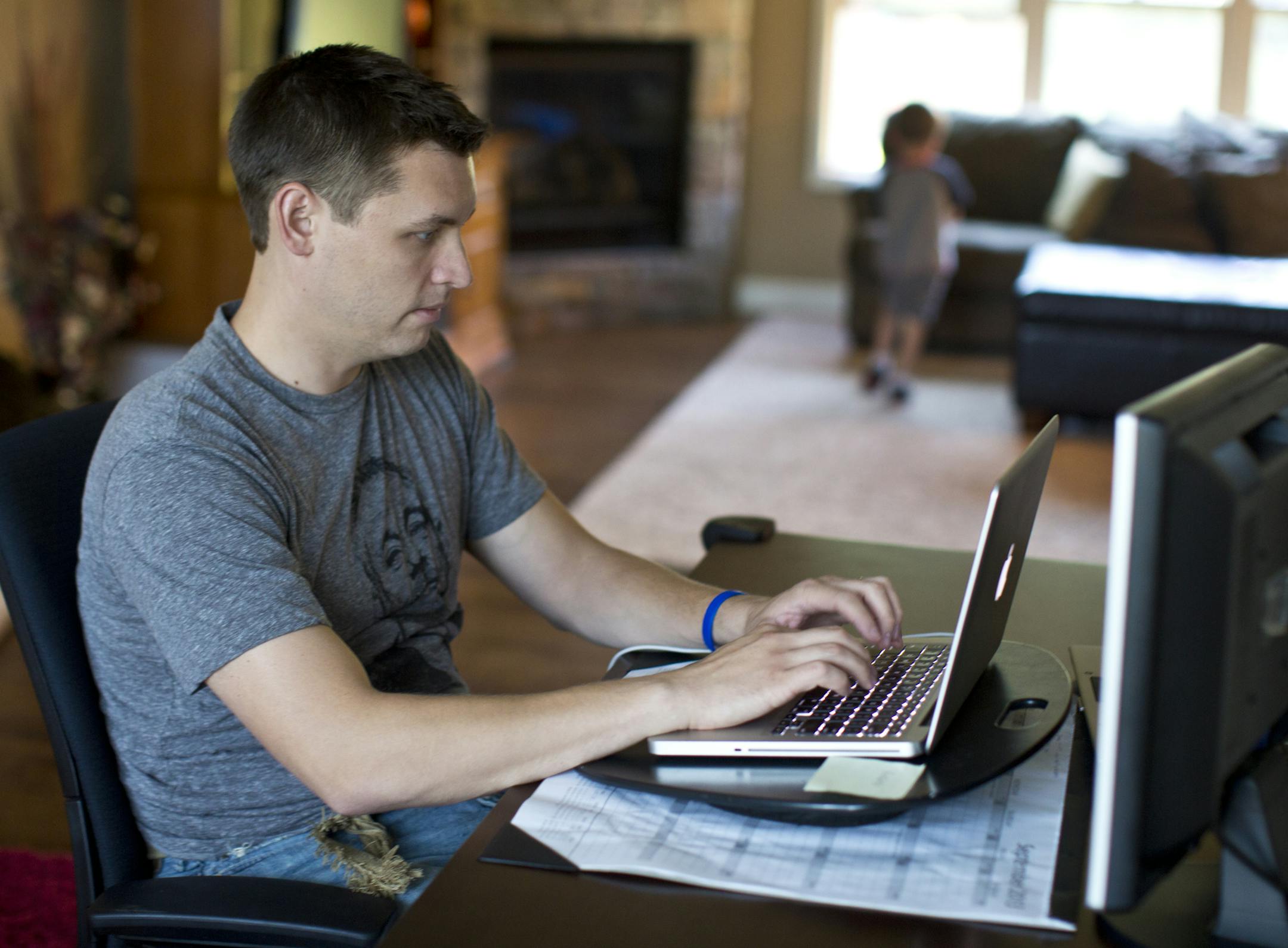 Adam Weller worked on a paper while his son John, 5, played with his cars at home in Savage, Minn., on Tuesday, September 25, 2013. Weller is one of the first students at Capella University to take one of its new brand of FlexPath courses. He says the self-paced courses work well with his busy schedule, but "I could definitely see drawbacks for folks who are not extremely self-motivated and disciplined." ] (RENEE JONES SCHNEIDER ‚Ä¢ reneejones@startribune.com)