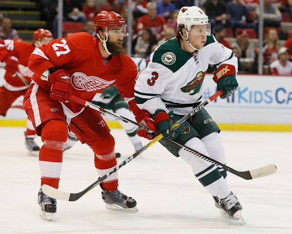 Detroit Red Wings' Kyle Quincey (27) tries to hold off Minnesota Wild's Charlie Coyle (3) during the first period of an NHL hockey game Friday, April 
