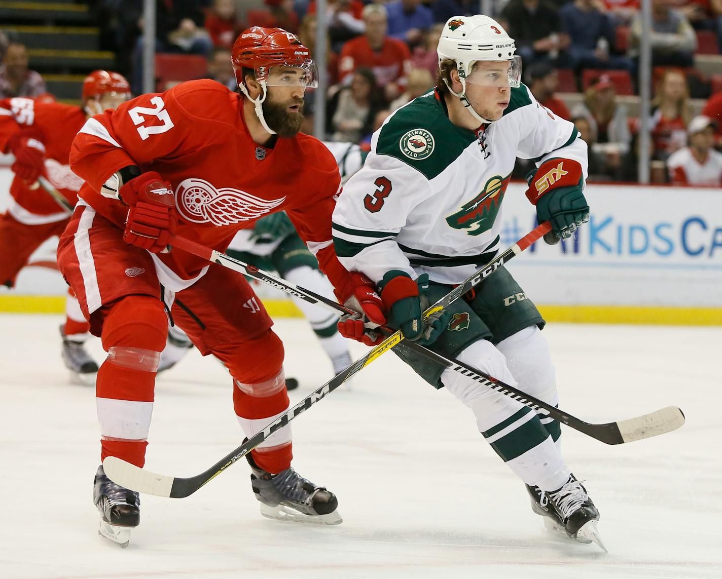 Detroit Red Wings' Kyle Quincey (27) tries to hold off Minnesota Wild's Charlie Coyle (3) during the first period of an NHL hockey game Friday, April 1, 2016, in Detroit. (AP Photo/Duane Burleson)