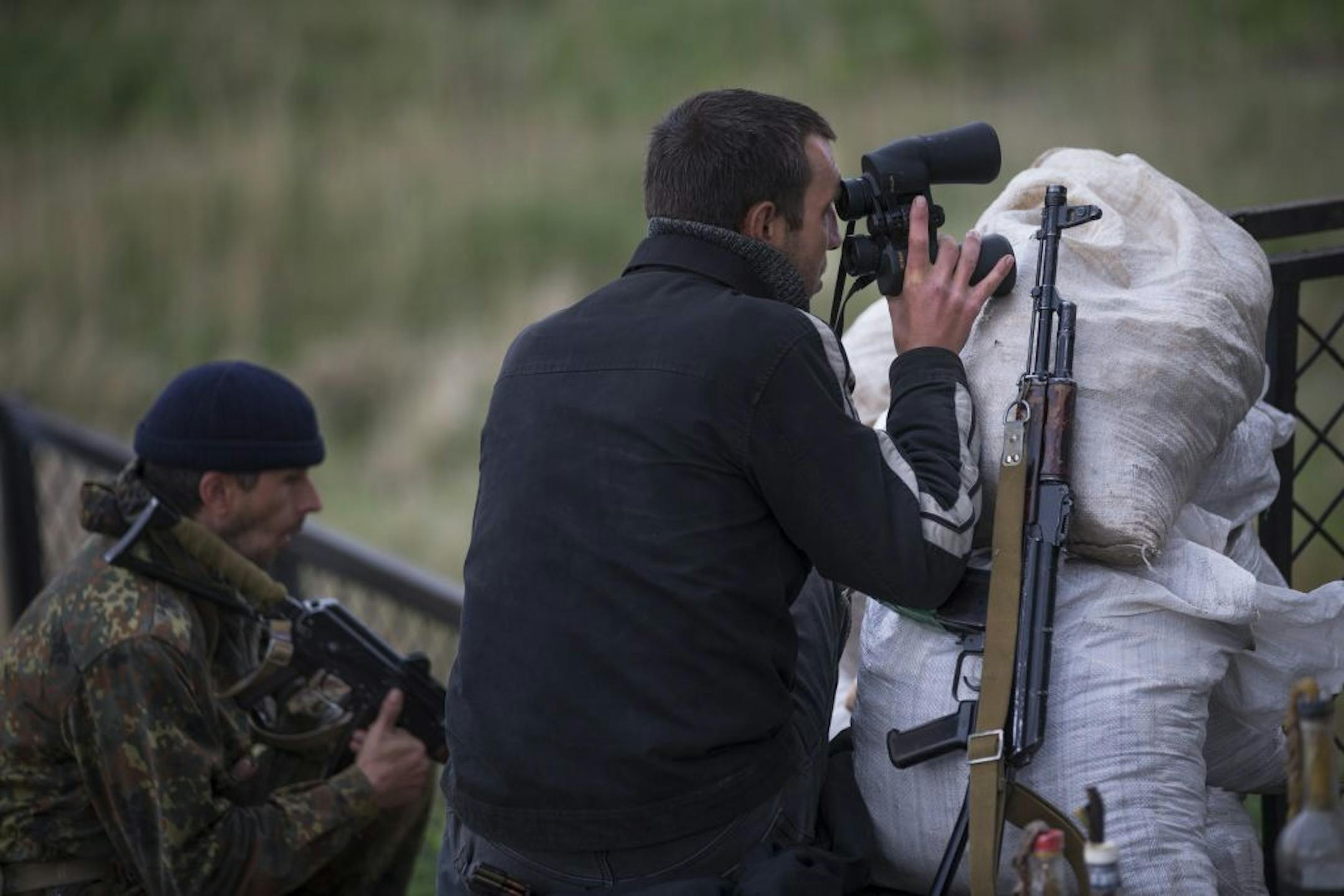 Armed pro-Russian men guard the barricades near the railway in Andreevka, few kilometers south of Slovyansk, Ukraine, Monday, May 5, 2014. Ukrainian troops fought pitched gun battles Monday with a pro-Russia militia occupying an eastern city, and the government sent an elite national guard unit to re-establish control over the southern port city of Odessa.