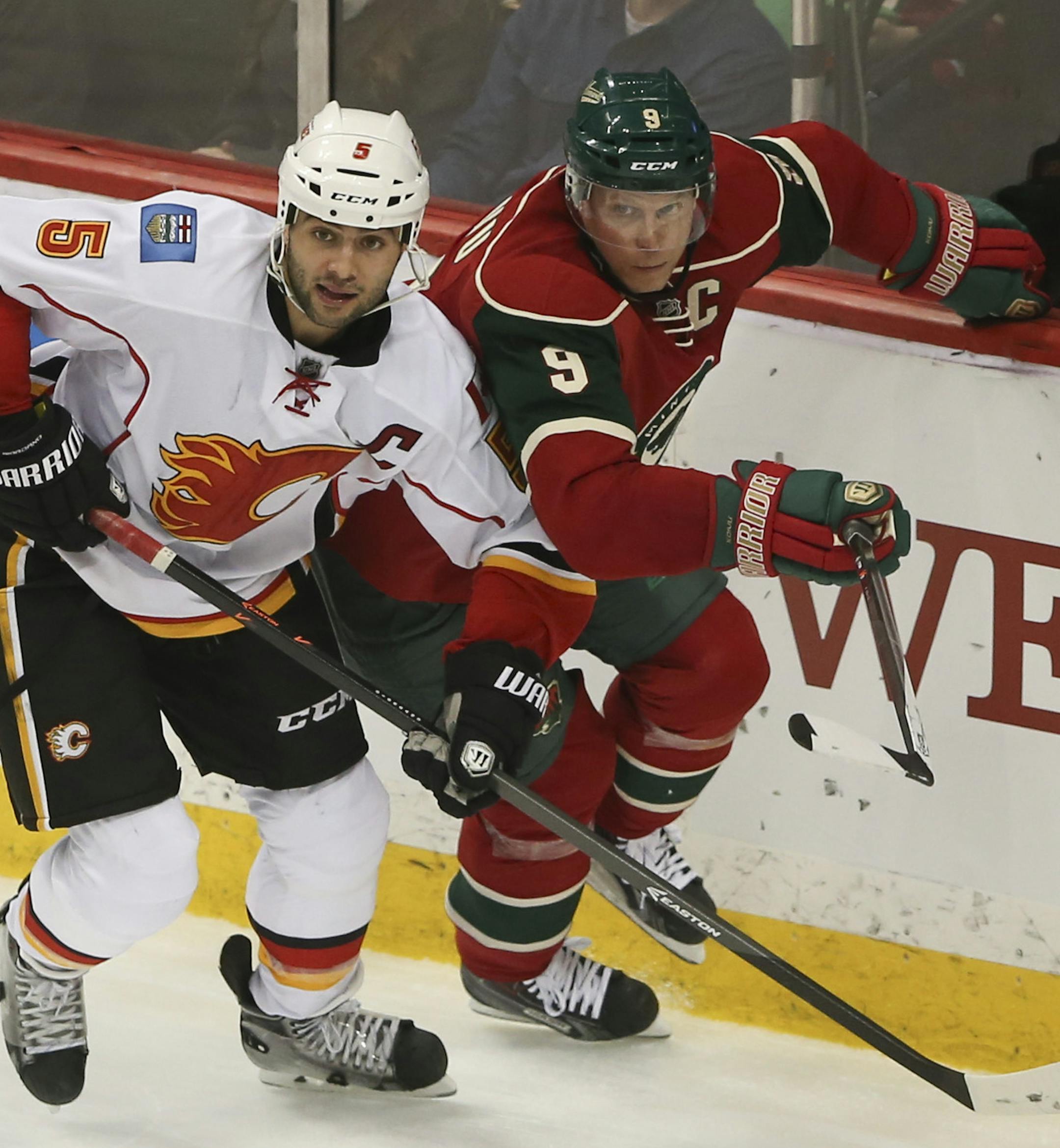 The Minnesota Wild beat the Calgary Flames 3-2 in an NHL hockey game Monday night, March 3, 2014 at Xcel Energy Center in St. Paul. The Wild's Mikko Koivu and Calgary's Mark Giordano watched a puck bounce out of reach in the third period. ] JEFF WHEELER ‚Ä¢ jeff.wheeler@startribune.com