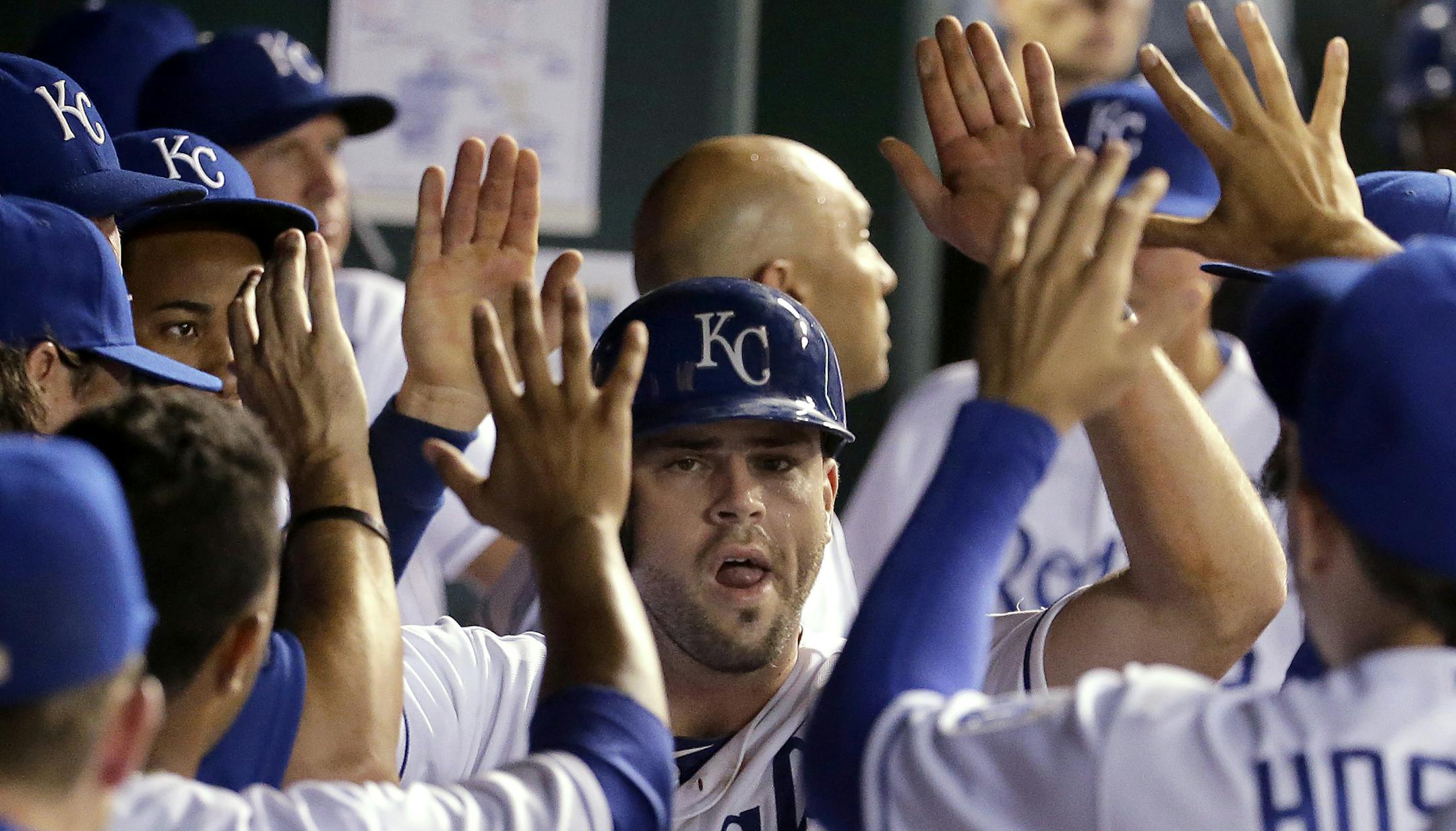 Kansas City Royals' Mike Moustakas celebrates in the dugout after scoring on a single by Norichika Aoki during the eighth inning of a baseball game against the Minnesota Twins on Wednesday, Aug. 27, 2014, in Kansas City, Mo. Kansas City won 6-1. (AP Photo/Charlie Riedel)