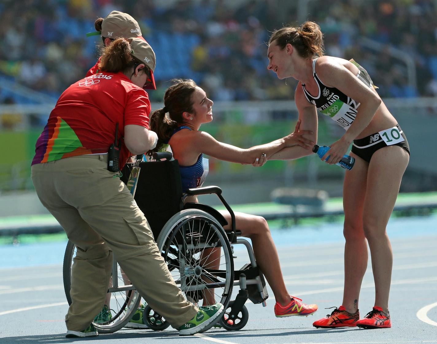 New Zealand's Nikki Hamblin reaches out a hand of thanks to USA's Abbey D'agostino (in chair) after the two tangled and fell during the 5,000 race heats and despite a torn ACL D'agostino stayed back to help Hamblin up. A pure sign of sportsmanship in a sea of competition. ] 2016 Summer Olympic Games - Rio Brazil brian.peterson@startribune.com Rio de Janeiro, Brazil - 08/17/2016 ORG XMIT: MIN1608171759220875