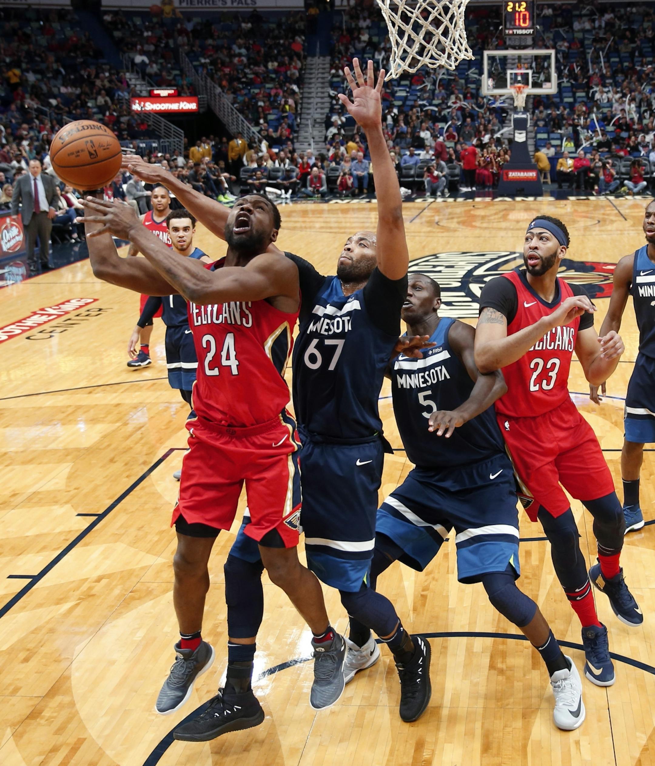 Minnesota Timberwolves forward Taj Gibson (67) swats the ball from New Orleans Pelicans guard Tony Allen (24) as Timberwolves center Gorgui Dieng (5) and Pelicans forward Anthony Davis (23) vie for position during the first half of an NBA basketball game in New Orleans, Wednesday, Nov. 29, 2017.