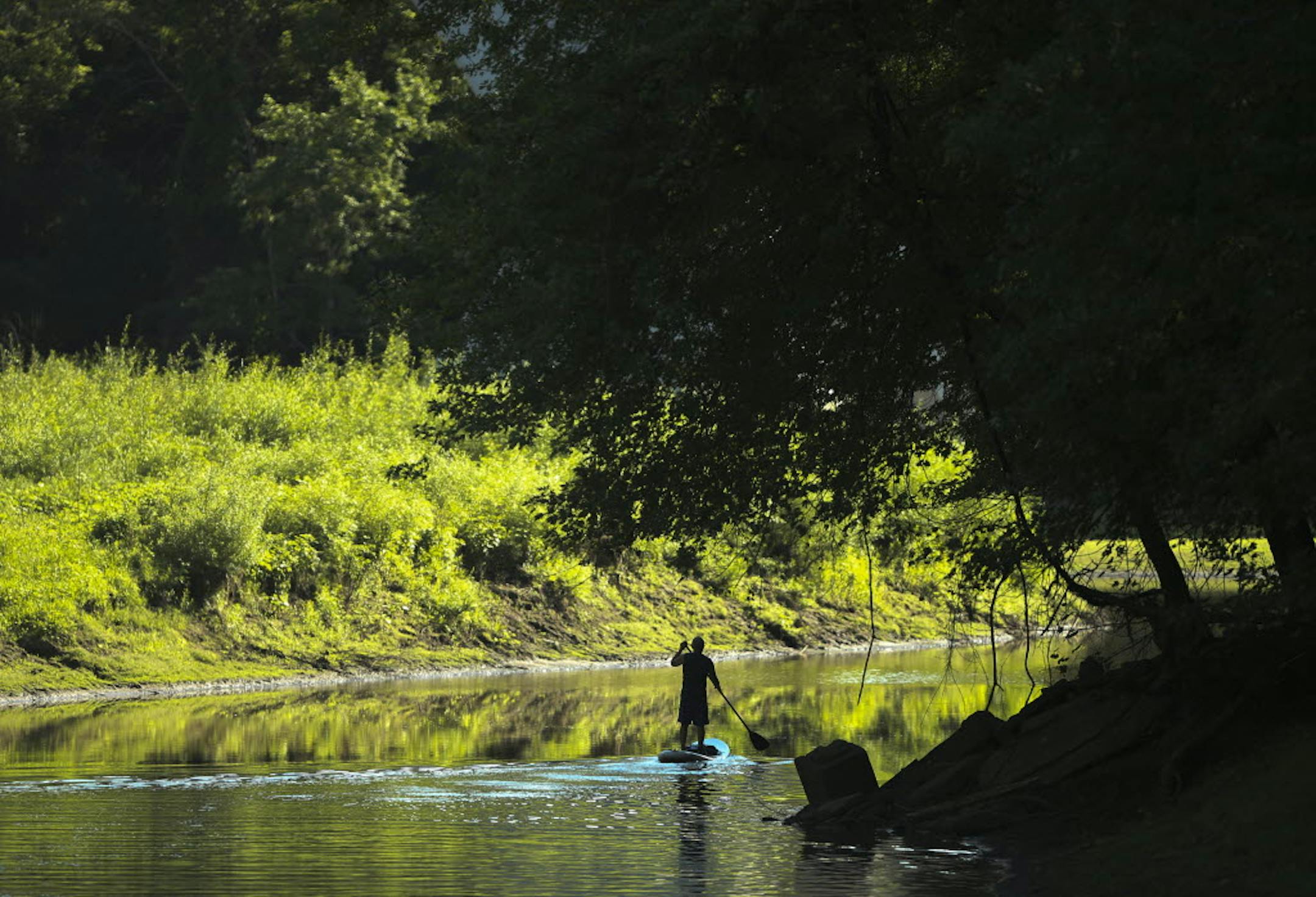 A cold and wet start to spring put a damper on state park vehicle permit sales, but attendance rebounded as summer heated up. John Tamminen found Tuesday’s weather perfect for using his paddleboard at Fort Snelling State Park.
