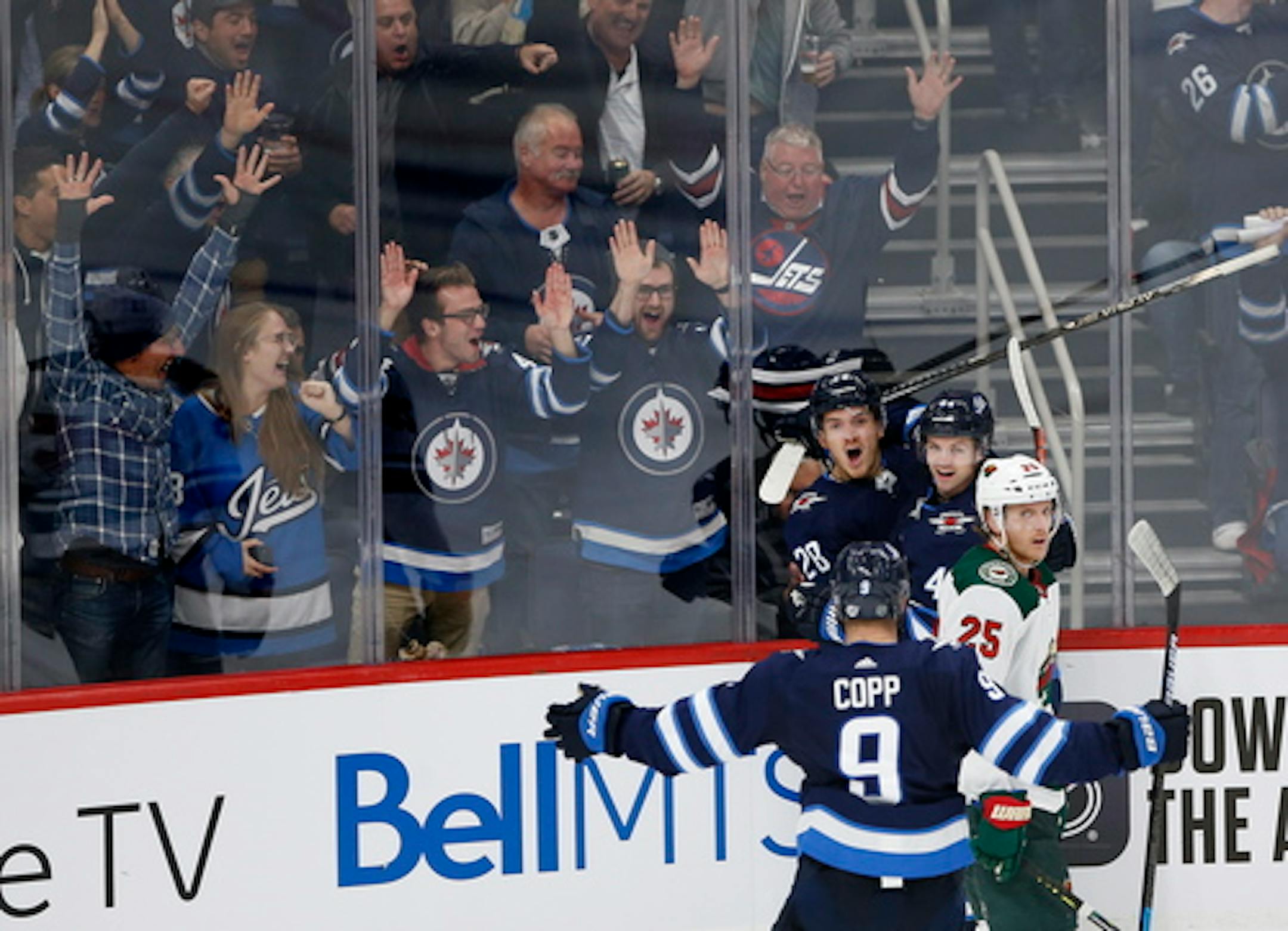 Winnipeg Jets' Jack Roslovic (28), Josh Morrissey (44) and Andrew Copp (9) celebrate Roslovic's goal against the Minnesota Wild as Jonas Brodin (25) skates by during the third period of an NHL hockey game Thursday, Oct. 10, 2019, in Winnipeg, Manitoba. (John Woods/The Canadian Press via AP)