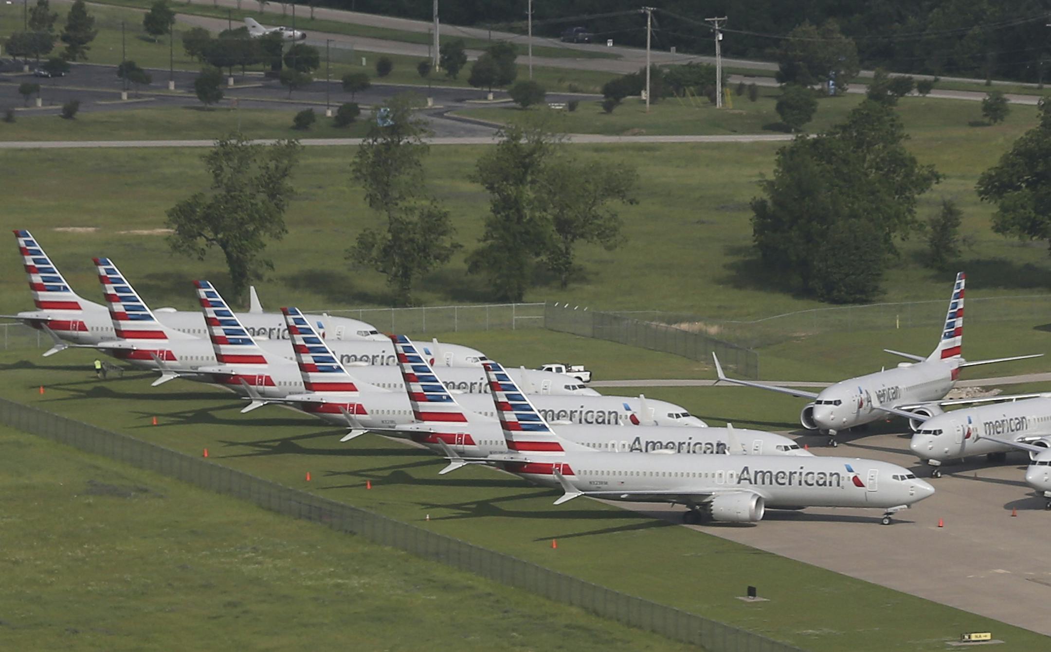 In a May 24, 2019 aerial photo, American Airlines 737 Max are stored at Tulsa International Airport. Boeing Co. said Monday, Dec. 16, 2019 that it will temporarily stop producing its grounded 737 Max jet starting in January 2020 as it struggles to get approval from regulators to put the plane back in the air. (Tom Gilbert/Tulsa World via AP)
