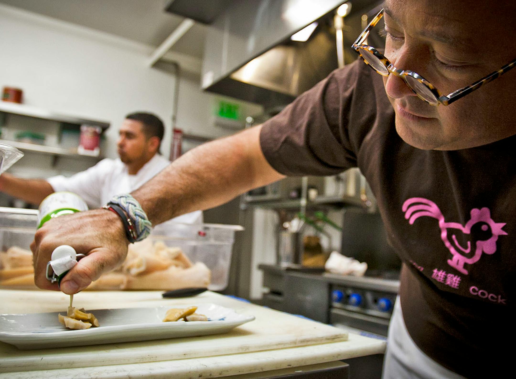 Bizarre Foods host and Chef Andrew Zimmern prepares gooey duck with Yuzu pickled vegetables for a pop-up dinner for an episode of the upcoming season, Thursday, Jan. 12, 2012, at the Crown T in Culver City, California.