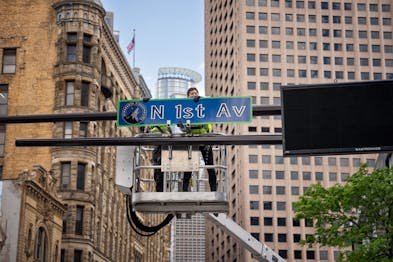 Minneapolis Mayor Jacob Frey participates in the hanging today of a ceremonial street honoring the Timberwolves across from Target Center, along with 