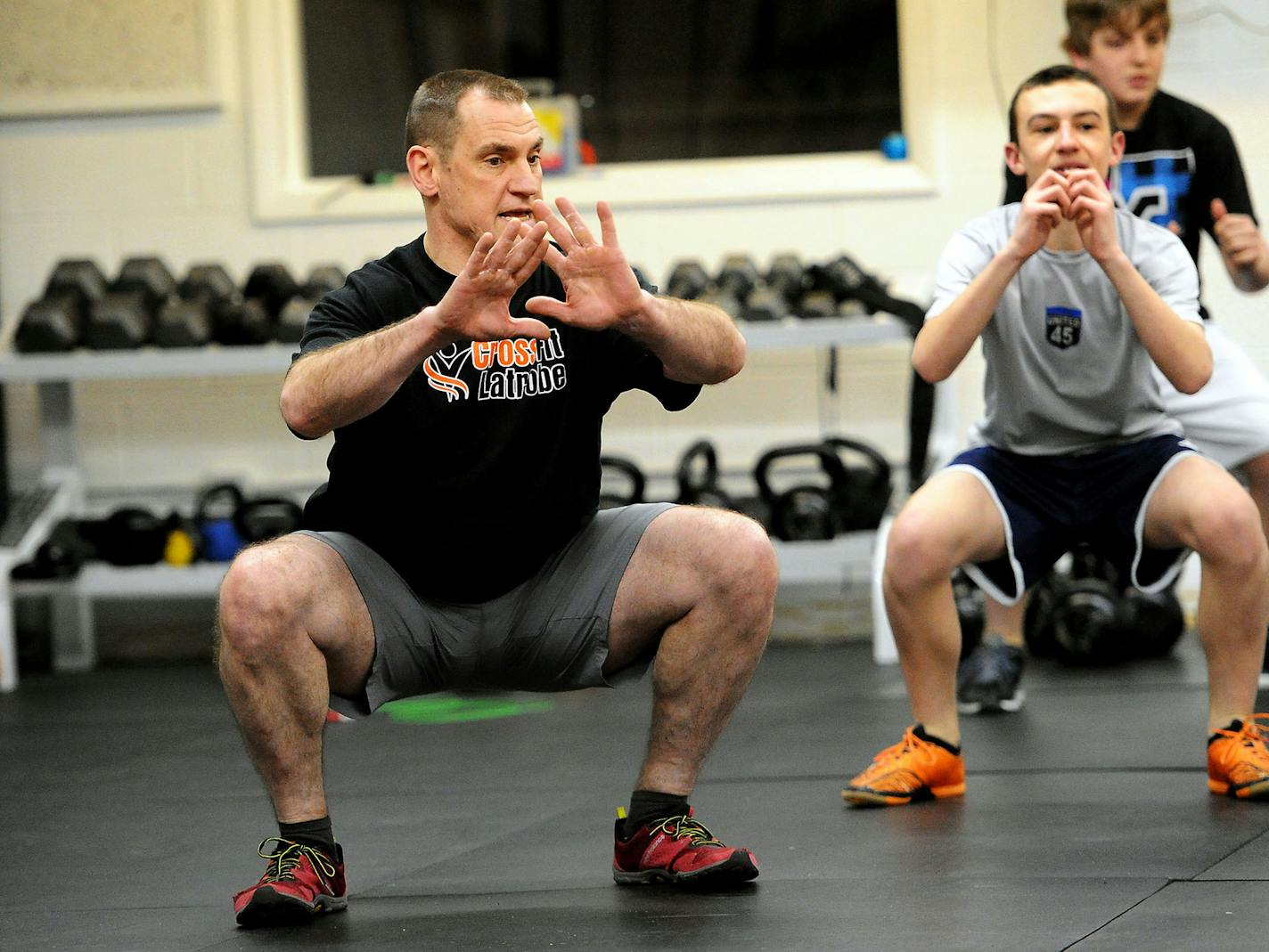 Patrick Landry, a certified CrossFit instructor, shows the proper way to do squats. Landry is one of only a handful instructors certified to teach CrossFit to children. (John Heller/Pittsburgh Post-Gazette/TNS) ORG XMIT: 1165717