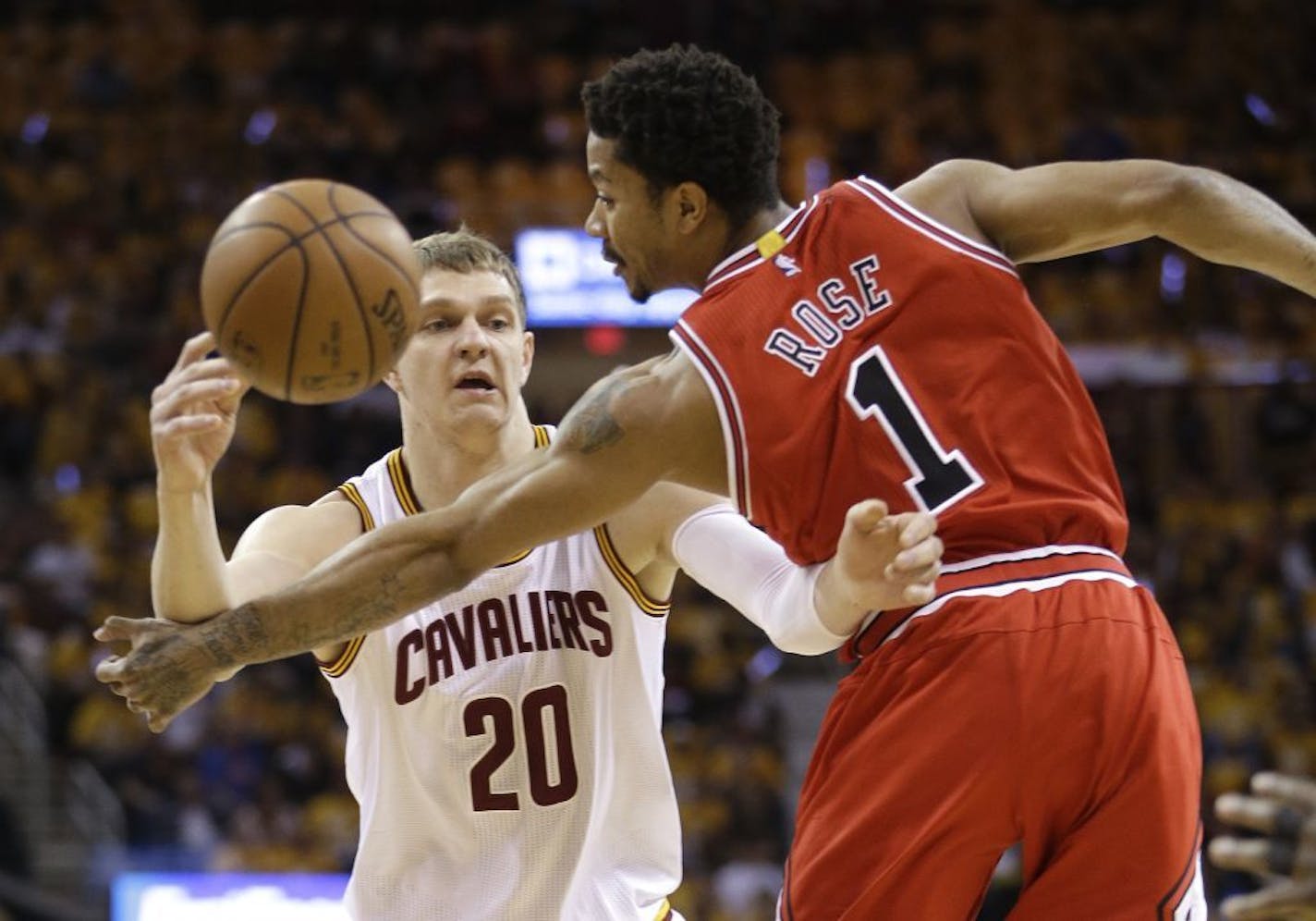 Cleveland Cavaliers center Timofey Mozgov (20) passes against Chicago Bulls guard Derrick Rose (1) during the first half of Game 1 in a second-round NBA basketball playoff series Monday, May 4, 2015, in Cleveland.