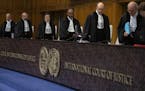 Presiding judge Abdulqawi Ahmed Yusuf, center, and other judges take their seats at the International Court in The Hague, Netherlands, Thursday, Jan. 