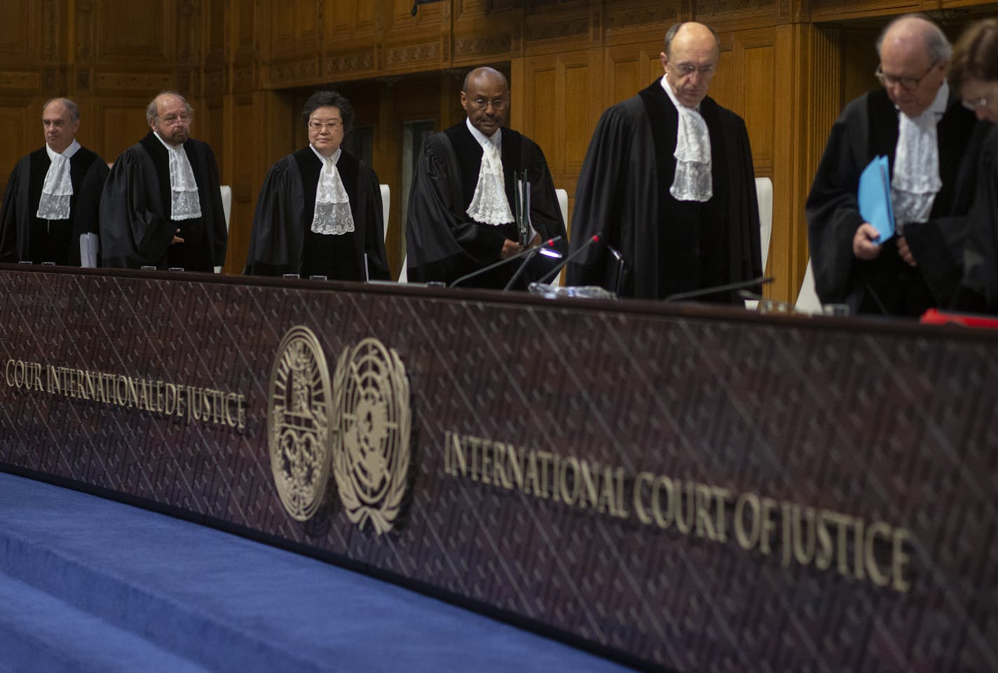 Presiding judge Abdulqawi Ahmed Yusuf, center, and other judges take their seats at the International Court in The Hague, Netherlands, Thursday, Jan. 23, 2020. The United Nations' top court is scheduled to issue a decision on a request by Gambia to order Myanmar to halt what has been cast as a genocidal campaign against the southeast Asian country's Rohingya Muslim minority. (AP Photo/Peter Dejong)