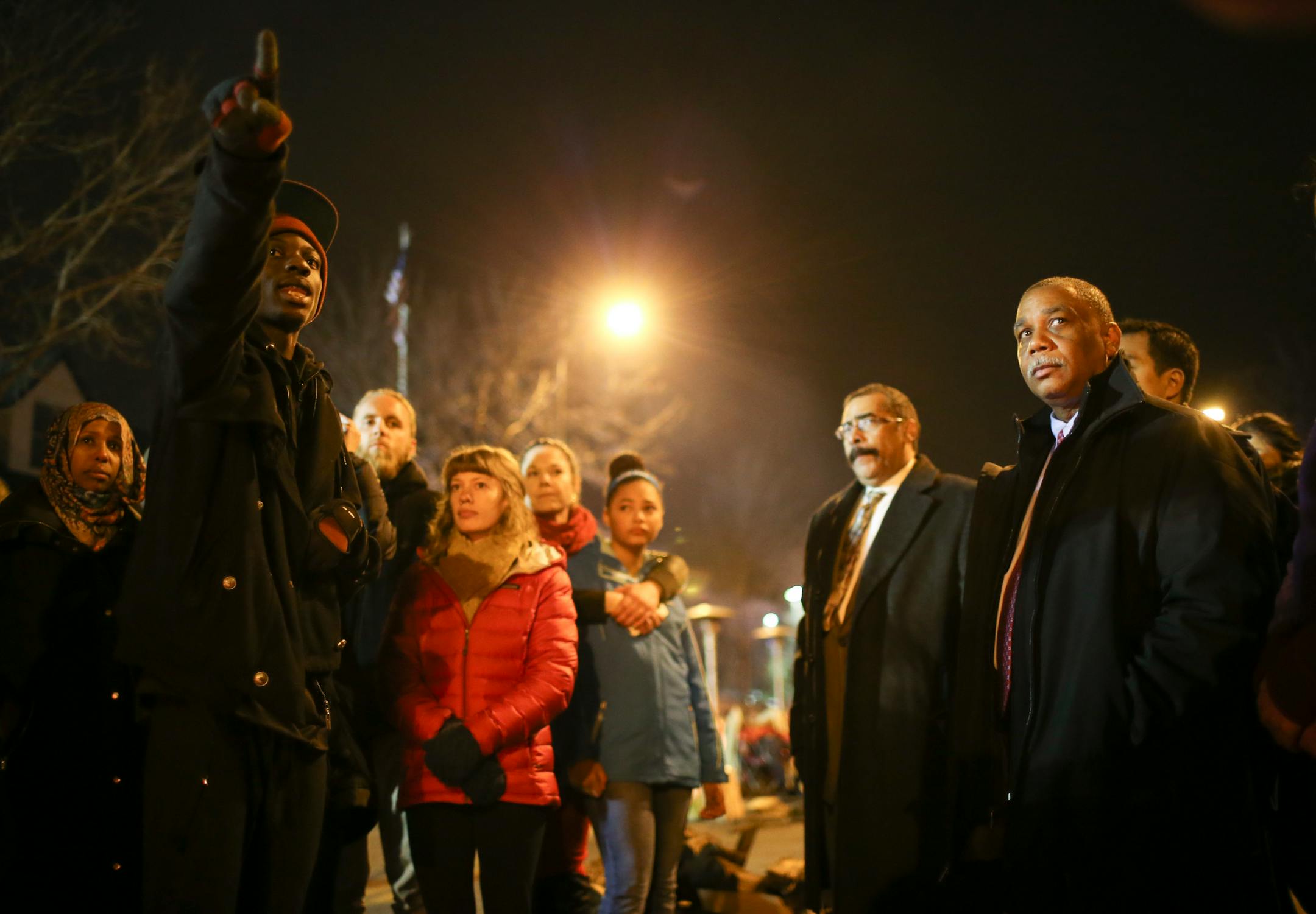 Emmanuel Kandolo, left, was one of a handful of demonstrators who took the opportunity to speak with two men who said they were with the U.S. Department of Justice late Wednesday night outside the Fourth Precinct police headquarters.
