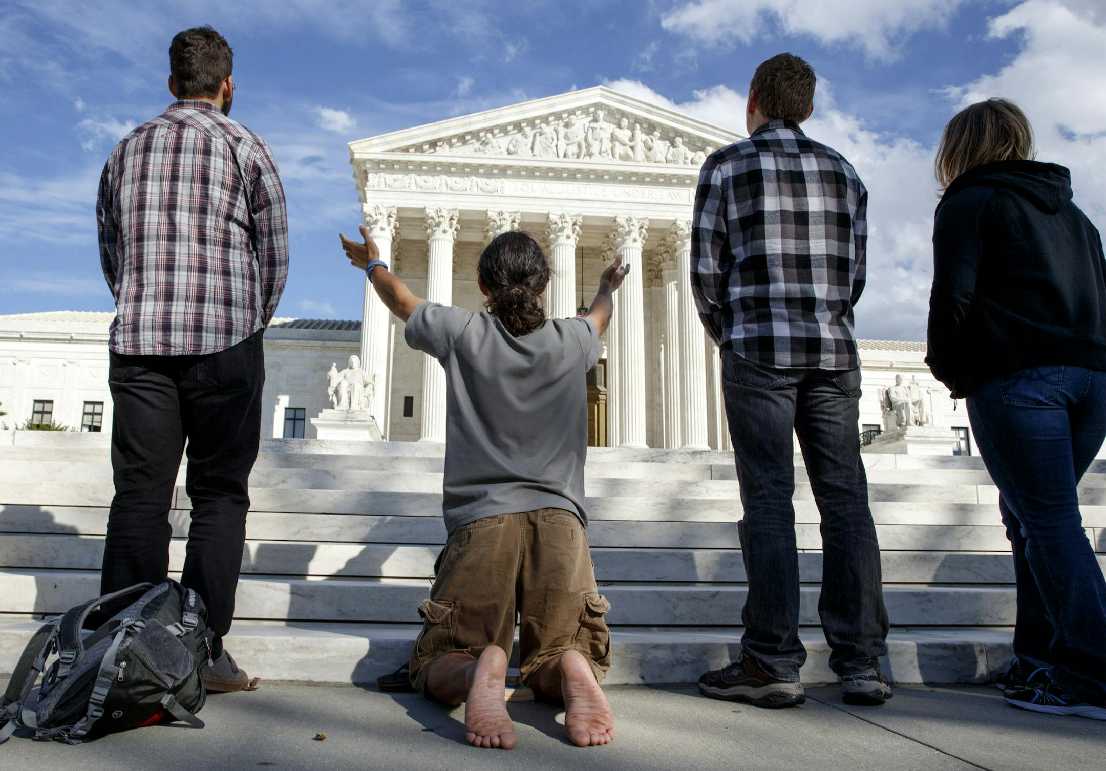 FILE - In this Oct. 4, 2014 file photo, as the U.S. Supreme Court begins its new term this week, pro-life advocates hold a prayer vigil on the plaza of the high court in Washington, Saturday, Oct. 4, 2014. The group, Bound 4 Life, has come to the court for ten years to make a silent appeal against abortion. Abortions have declined in states where new laws make it harder to have them - but theyíve also waned in states where abortion rights are protected, an Associated Press survey finds. Nea