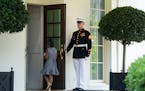 A Marine holds the door as Gianna Floyd, the daughter of George Floyd, walks into the White House, Tuesday, May 25, 2021, in Washington. (AP Photo/Eva
