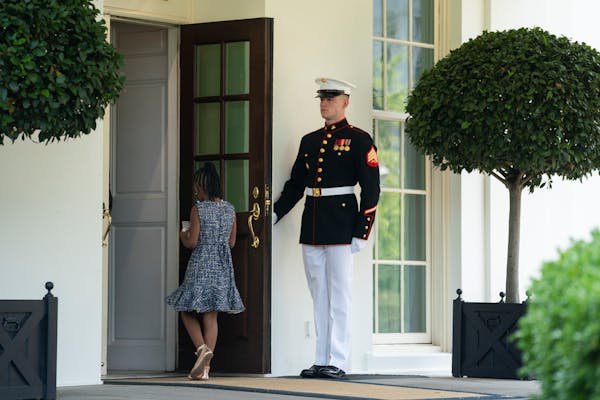A Marine holds the door as Gianna Floyd, the daughter of George Floyd, walks into the White House, Tuesday, May 25, 2021, in Washington. (AP Photo/Eva