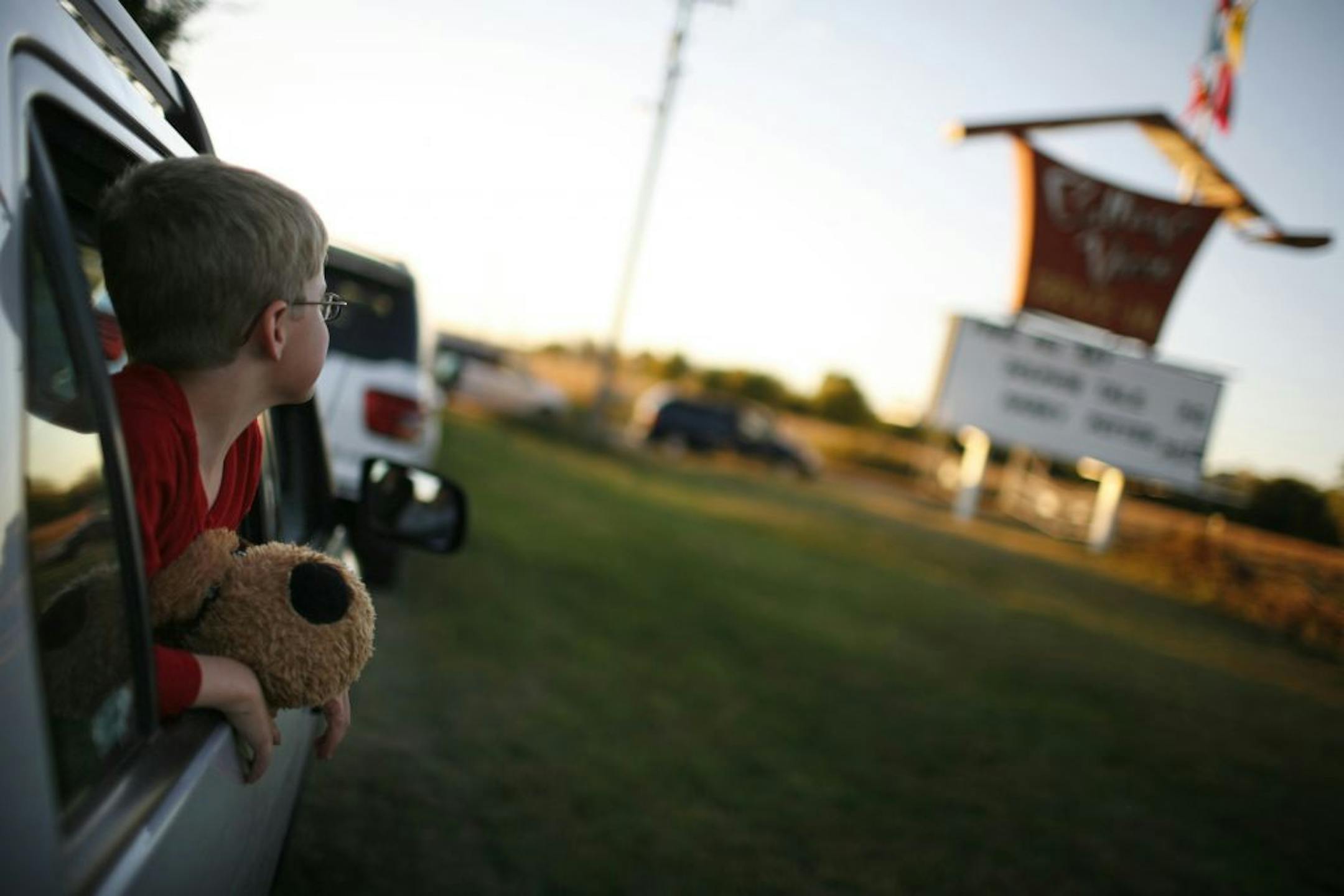 Logan Kocher, 6, waits in line with "Big Puppy" (along with mom and dad Phil and Gwen) for the gates to open for the last moview night of the season at the Cottage View Drive-In. It's the season's end at the Cottage View Drive-In while signalling that the theater, endangered in recent years by development possibilities, looks to be returning for another year in 2012.