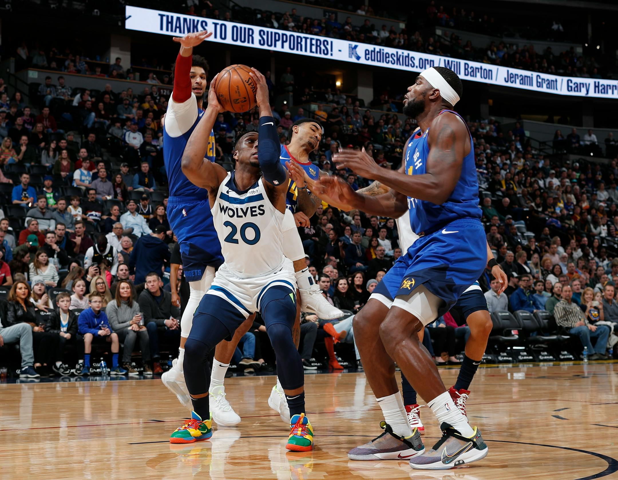 Minnesota Timberwolves guard Josh Okogie, front left, pulls in a rebound as Denver Nuggets forward Paul Millsap, front right, and guards Jamal Murray, back left, and Gary Harris defend in the first half of an NBA basketball game Friday, Dec. 20, 2019, in Denver. (AP Photo/David Zalubowski)