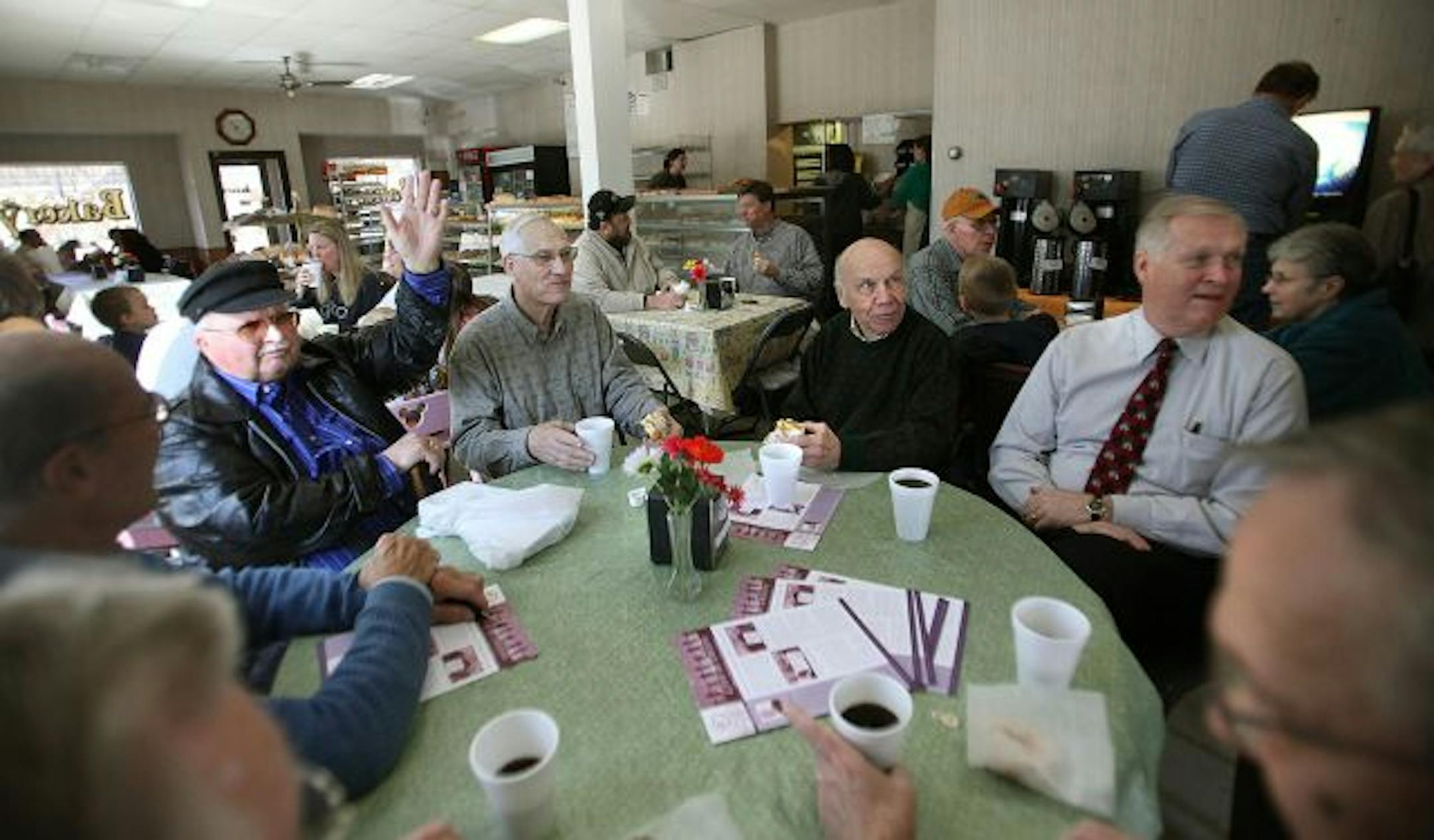A group of men, including from left, Curly Roberts, Marlyn Puppe, Ron Waits, Neil Harrington, Glenn Shull, Dick Upgren, and Dwight Crisman, greeted each other as they entered the Chaska Bakery for a last reunion during their last few days of business. Most of the men have gathered there everyday for as long as 30-plus years.