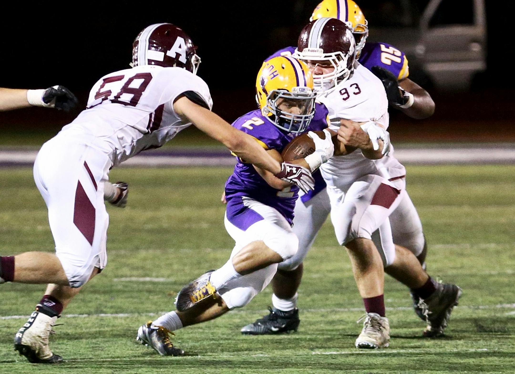 Cretin-Derham Hall senior running back Marquez Thompson breaks up the middle between two Anoka defenders as the Raiders go on to win 21-20.