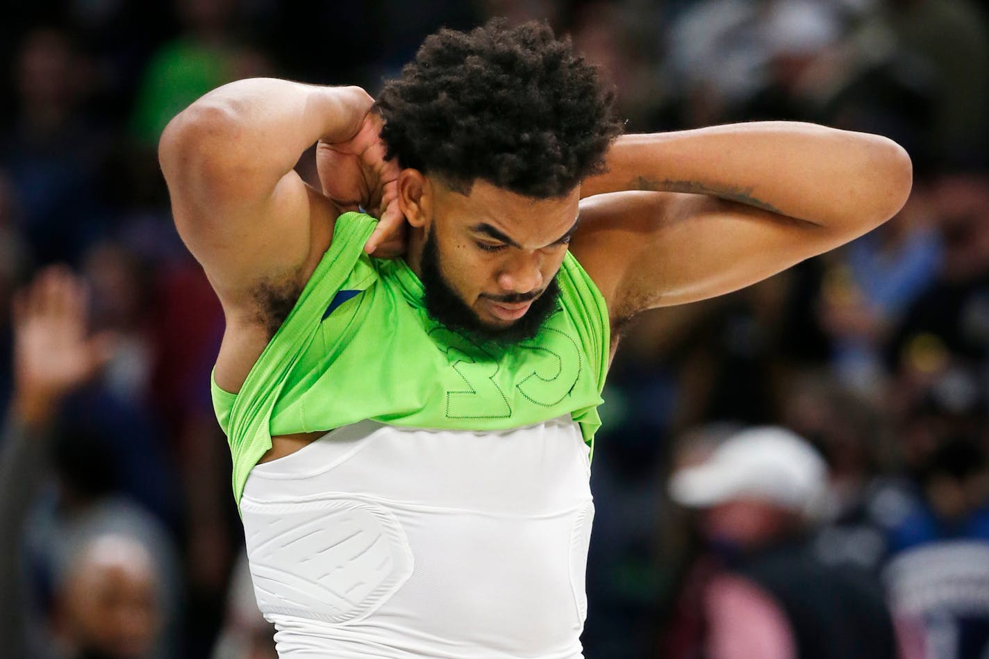 Minnesota Timberwolves center Karl-Anthony Towns wrestles with his jersey after losing to the Denver Nuggets at a NBA basketball game Saturday, Oct. 30, 2021, in Minneapolis. The Nuggets won 93-91. (AP Photo/Bruce Kluckhohn)