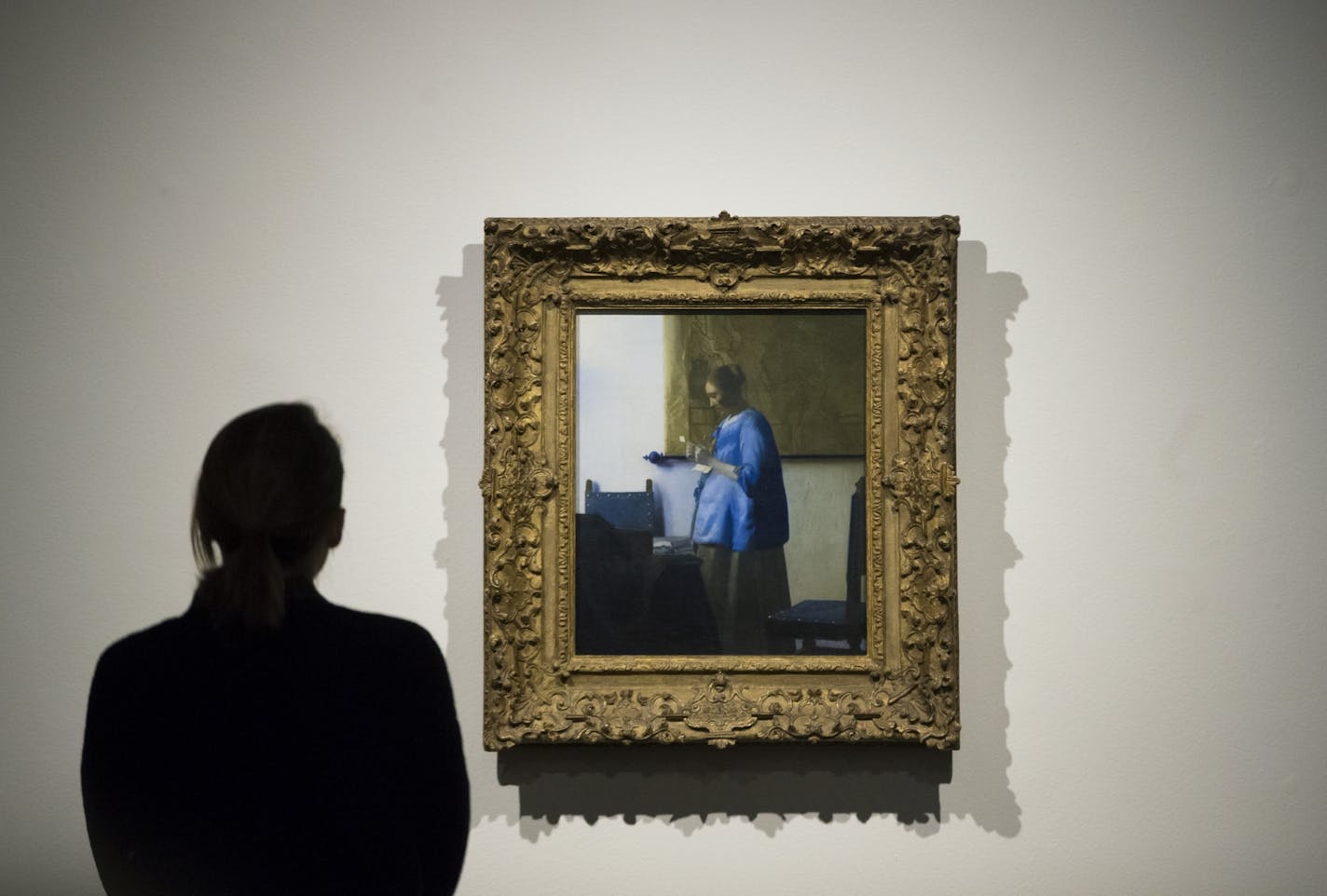 An MIA staff member got a close up look at Johannes Vermeer's Woman in Blue Reading a Letter at the staff unveiling of the Minneapolis Institute of Arts' first big "surprise" of its centennial year on Friday, January 16, 2015, in Mineapolis, Minn.