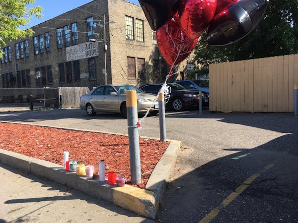 A makeshift memorial was set up in the alley just behind Cliff N Norms bar in Minneapolis, where one man was killed and three were injured by gunfire 