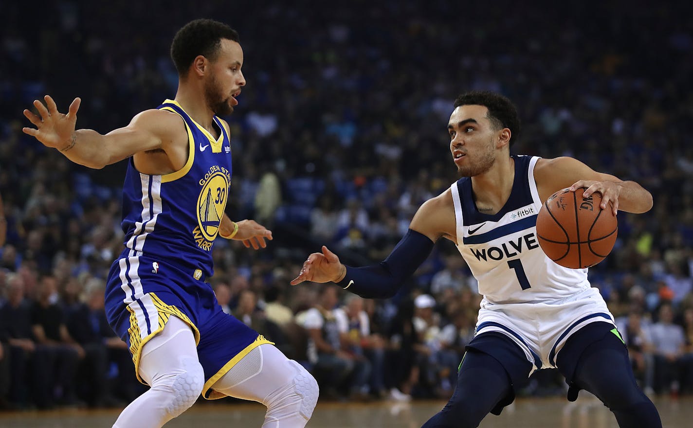 Golden State Warriors' Stephen Curry, left, defends against the Timberwolves' Tyus Jones on Friday. Jones missed the Wolves' previous game.