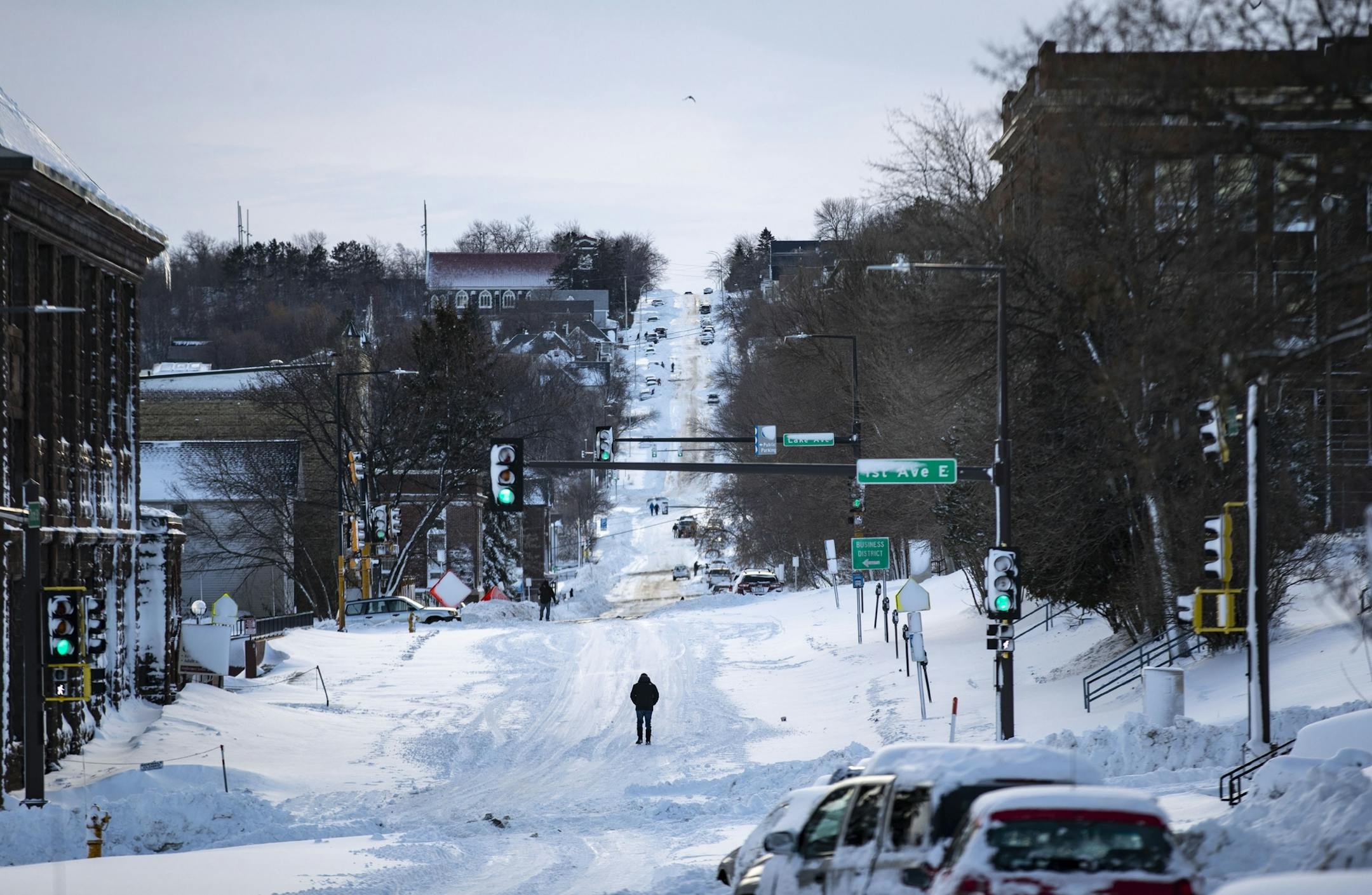 A man paused in the middle of a snow covered road Ibn Duluth, MN on Sunday afternoon.